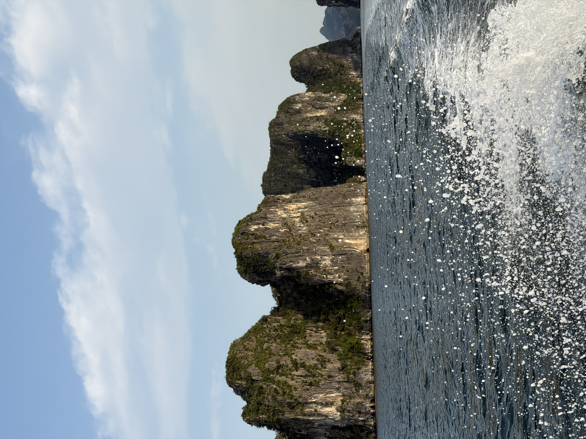 Tourist documents Ha Long Bay limestone formations from boat