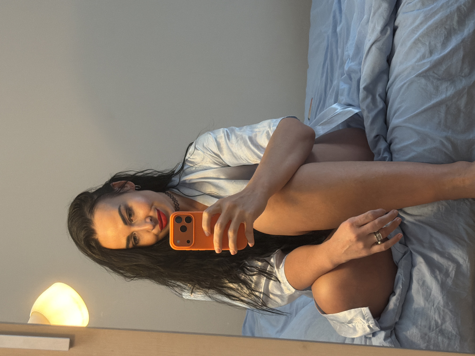 Woman takes bedroom selfies during afternoon photo session