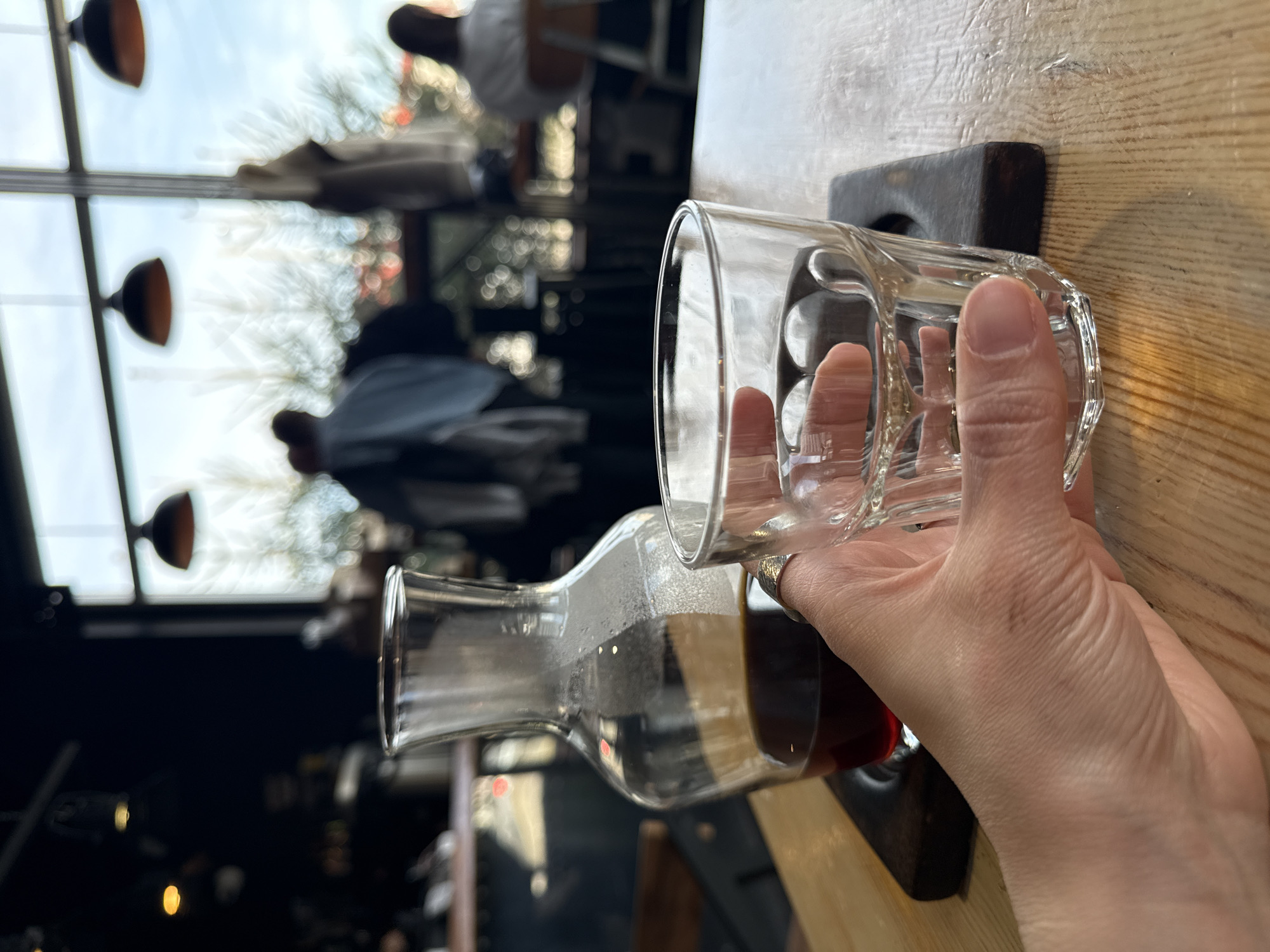 Person pours dark liquid from carafe into glass in Kazan