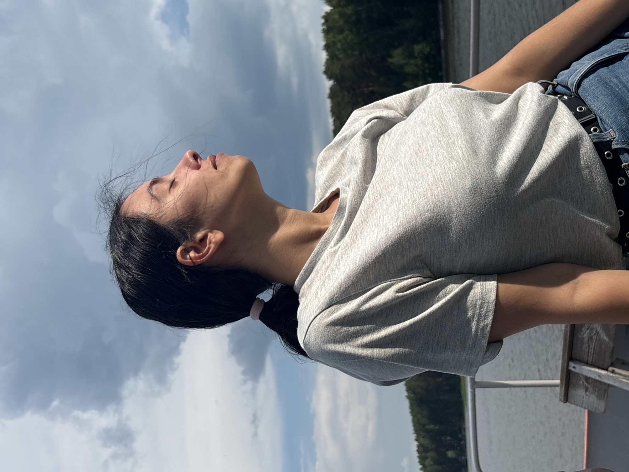 Woman enjoys quiet boat moments under cloudy skies in Chaykovsky