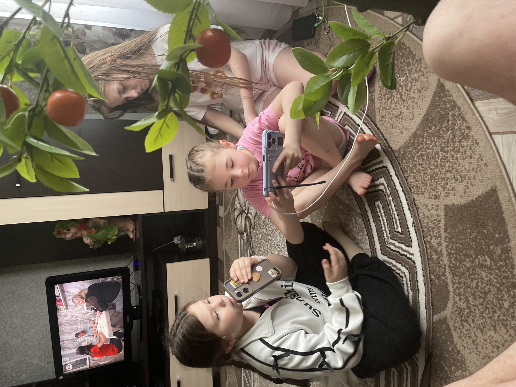 Children play indoors on rug in Nizhnii Bugrysh home