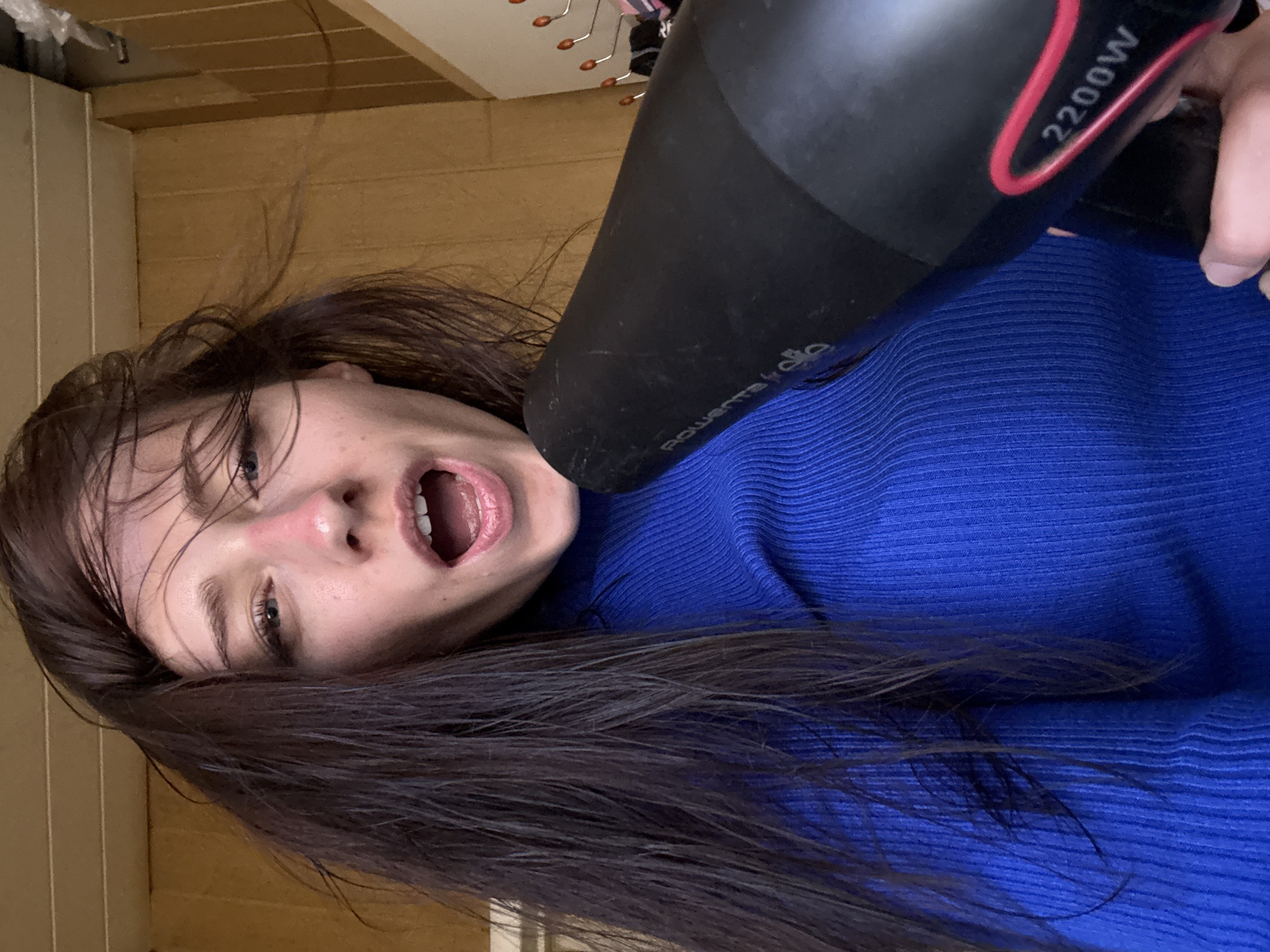 Woman dries hair indoors in Saint Petersburg apartment