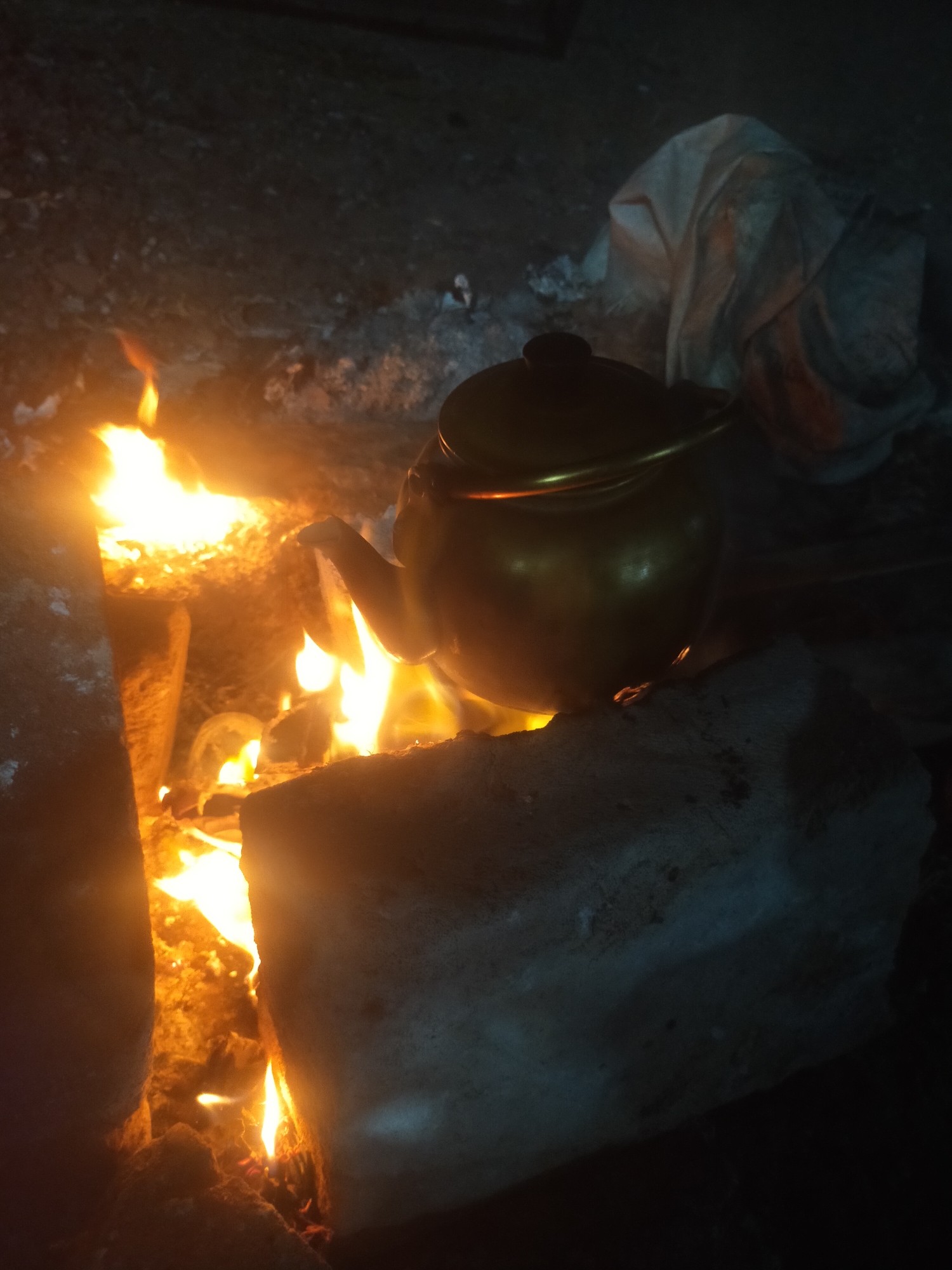 Brass kettle heating over open fire in Pagerbarang