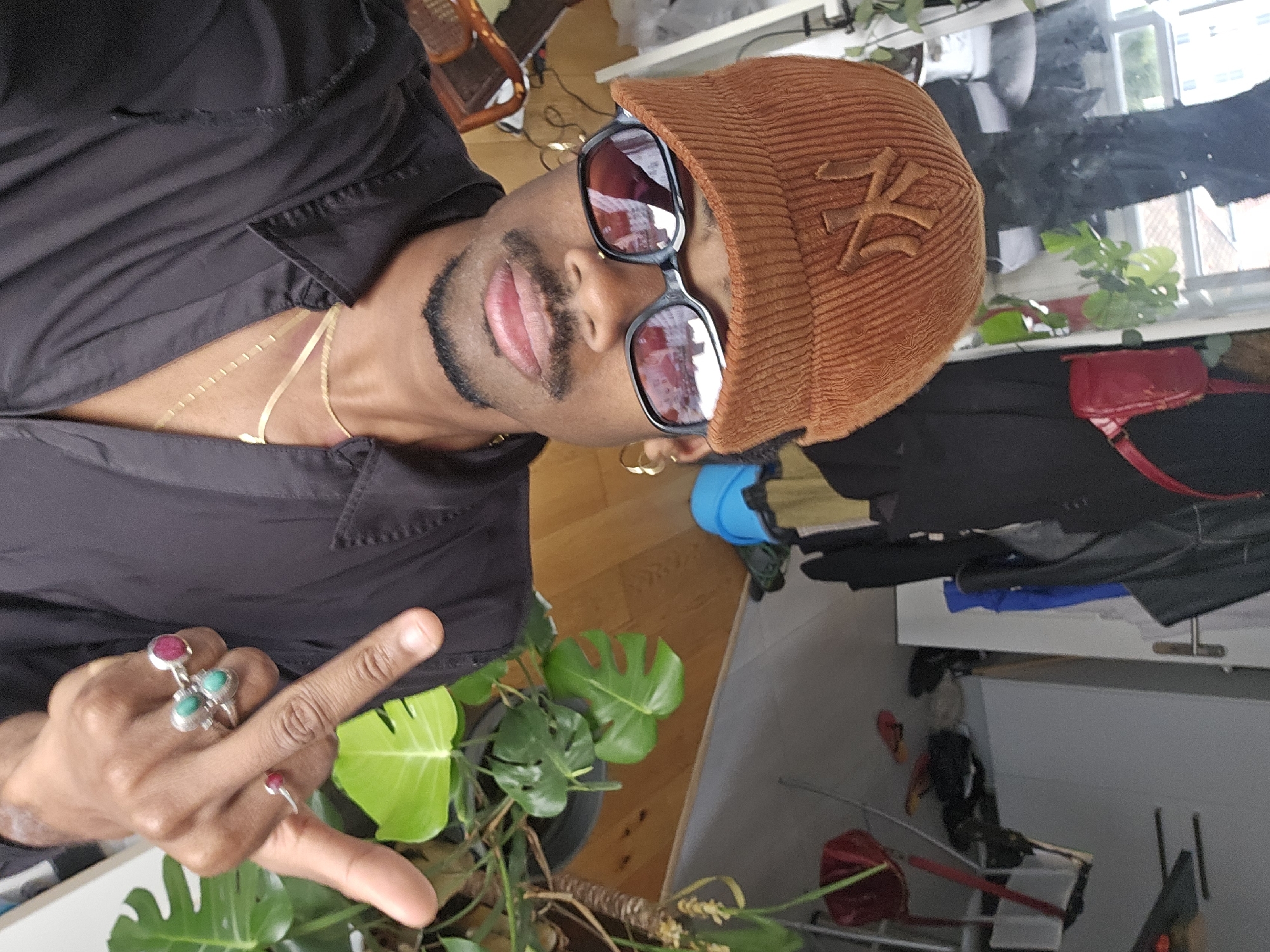Face-forward in Pantin: cap, shades, gold chains.
