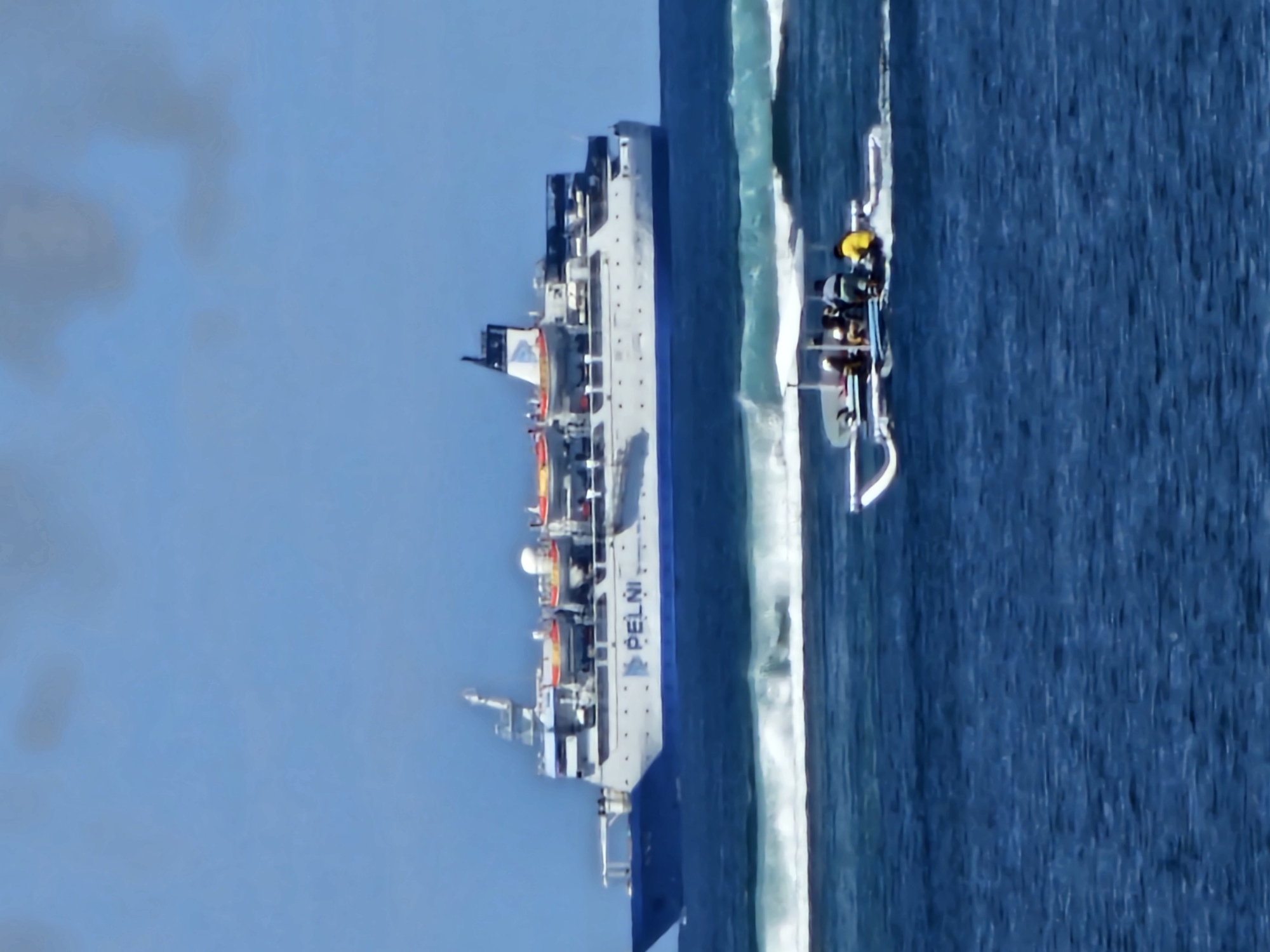 Paddleboarding in calm Bali waters as a PELNI ferry passes