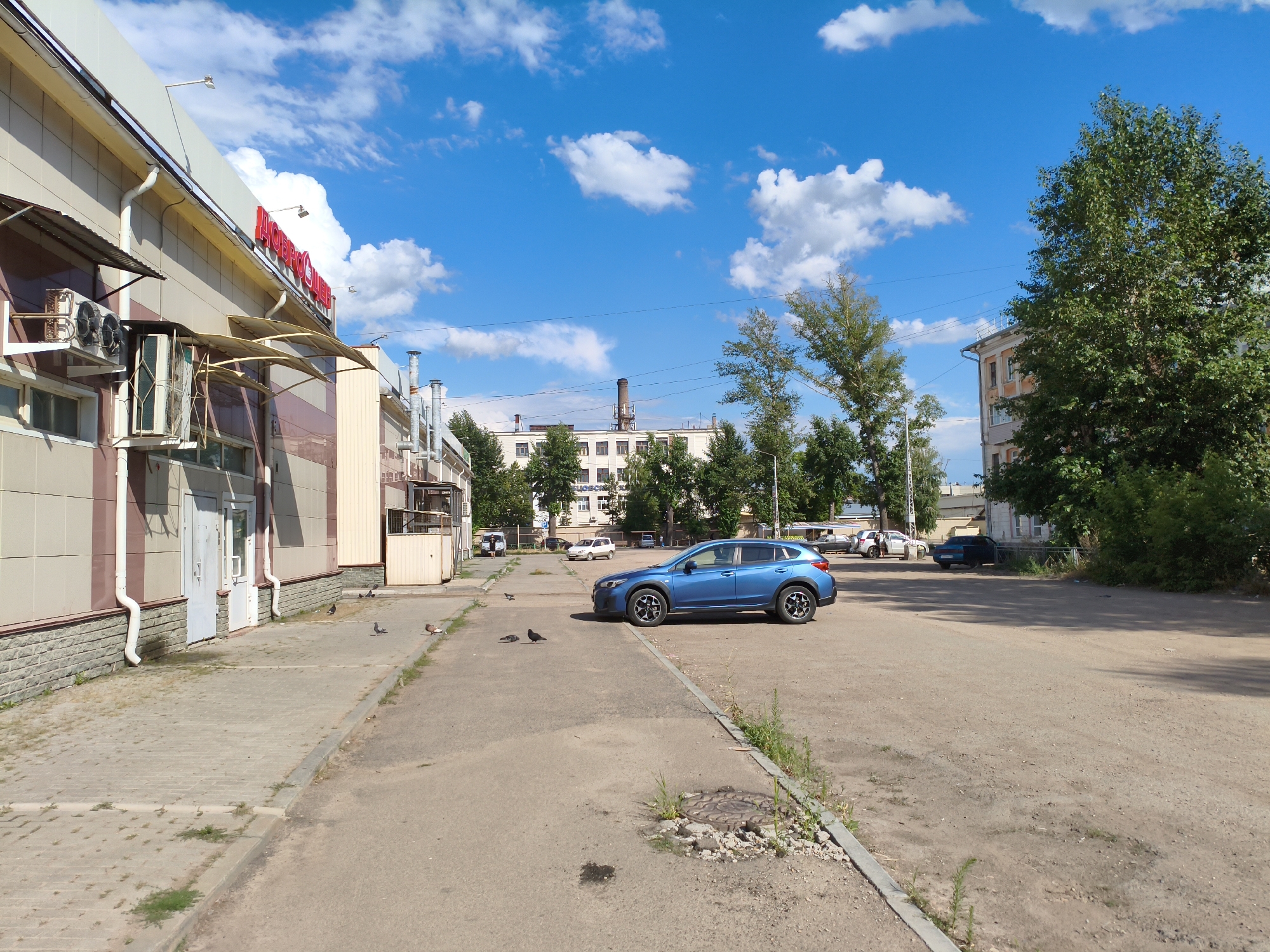 Older apartment complex, parked cars, and a vending machine mid-pour
