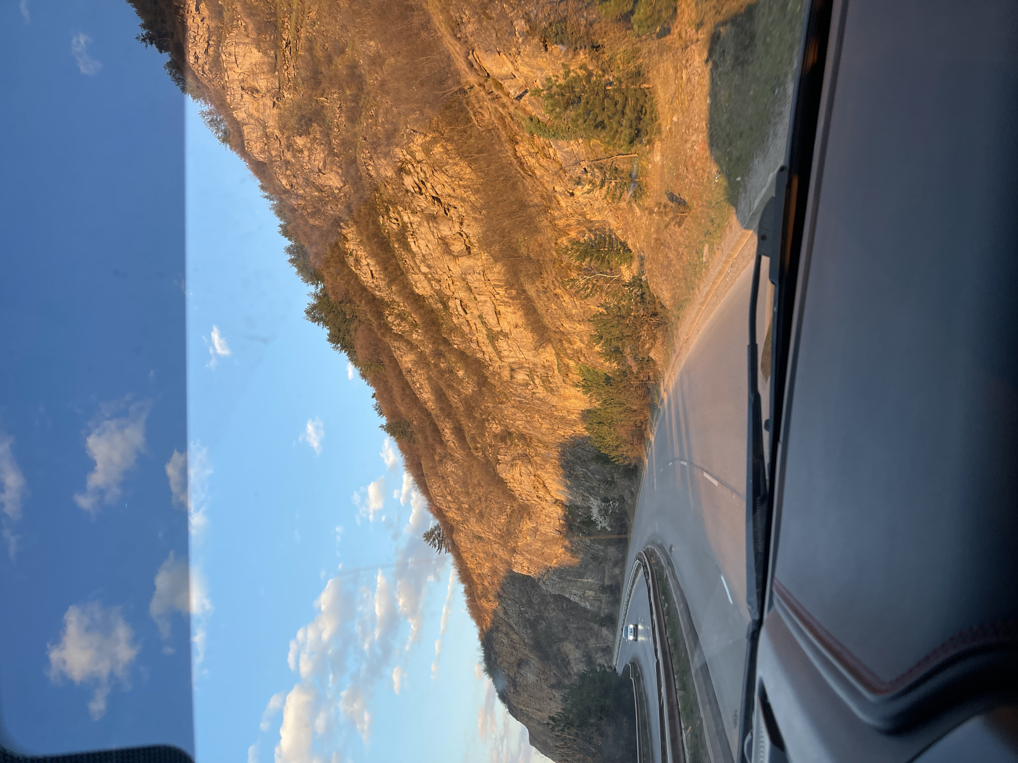 Vehicle travels past steep rock formation in Pernik, Bulgaria