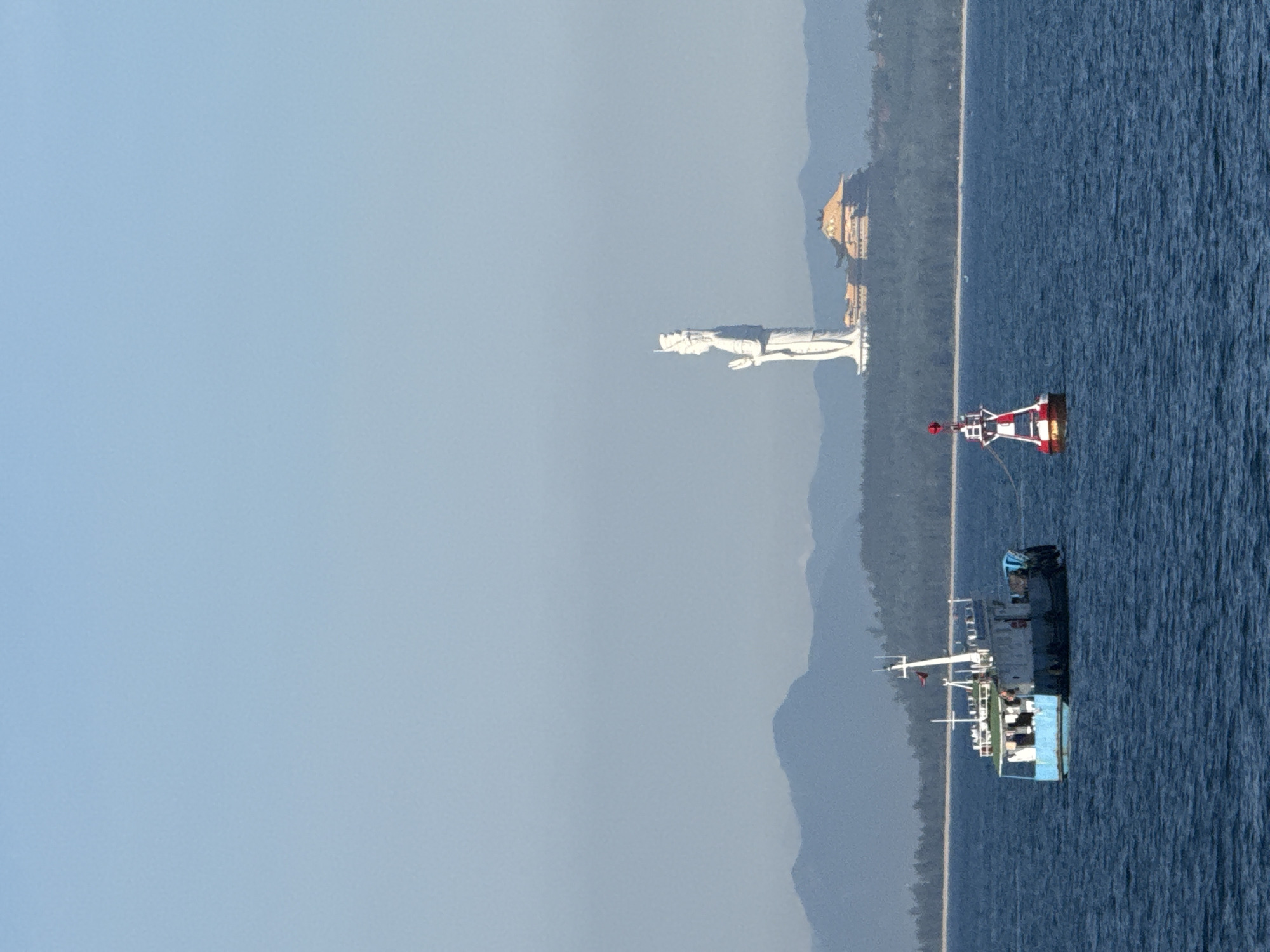 Fishing boats and a striped lighthouse off the central Vietnamese coast