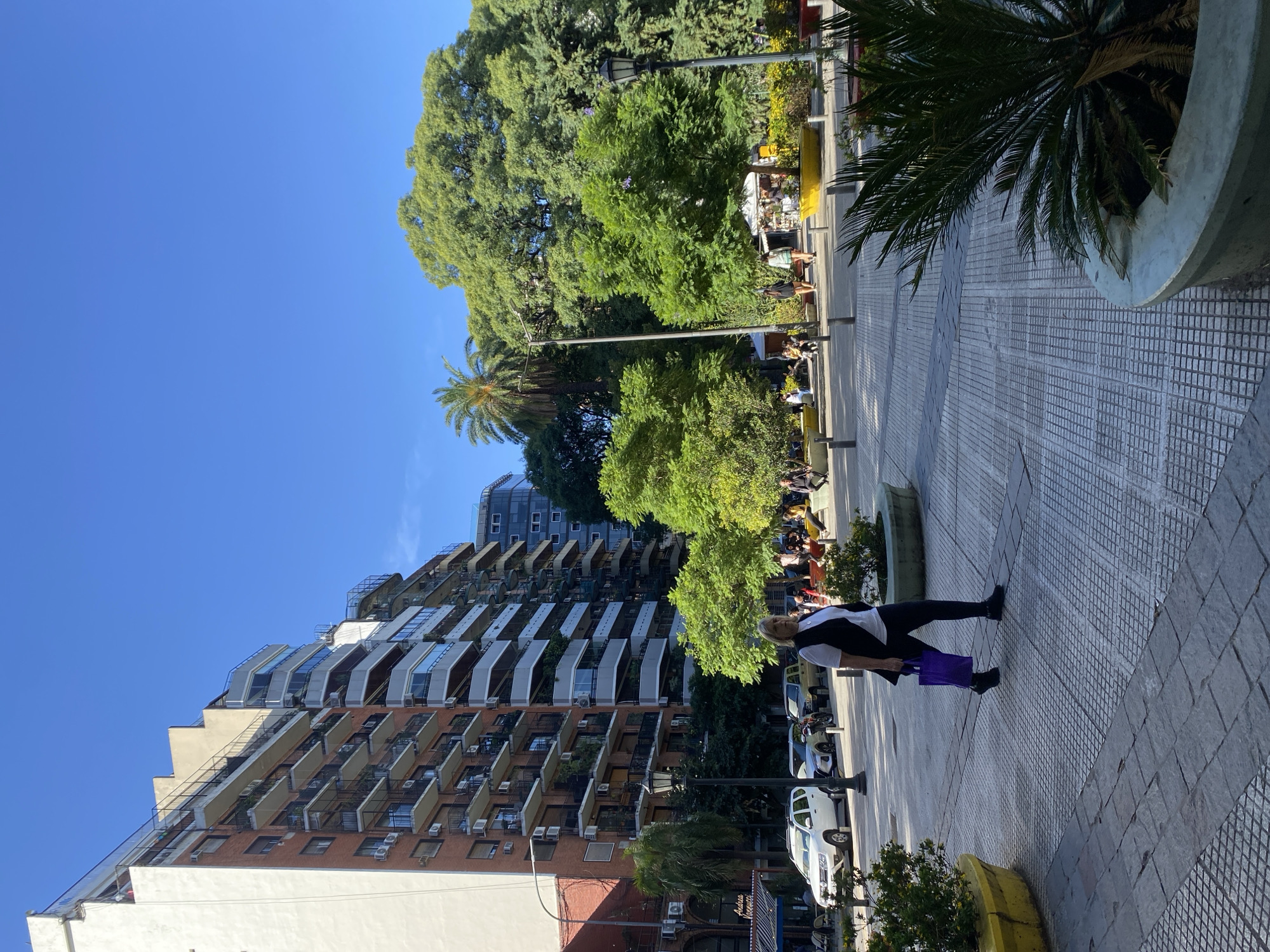Woman walks past modern apartment building in Buenos Aires