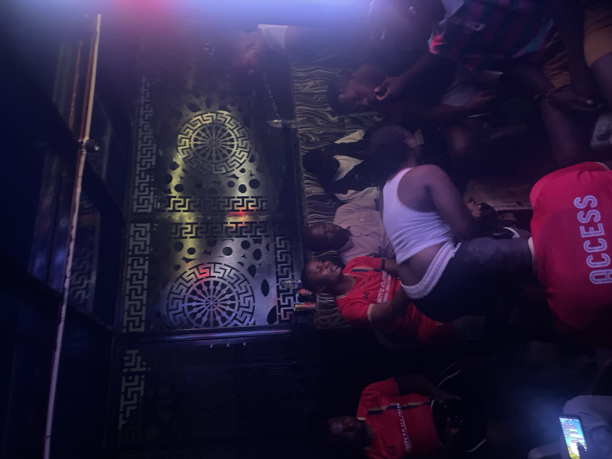 Late-night gathering at a neon-lit club in Kurunduma, Nigeria
