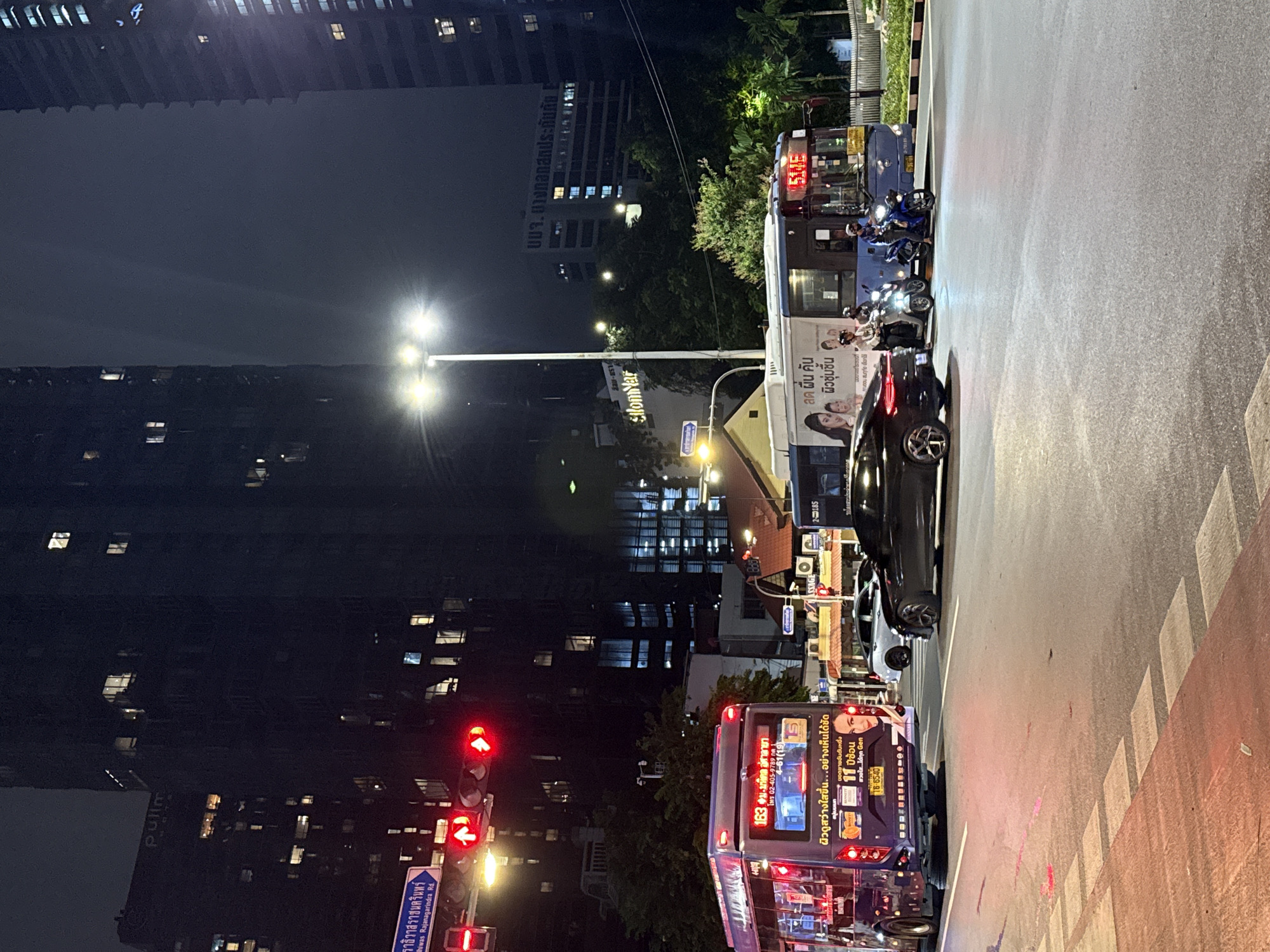 Wet Bangkok streets at night, live music inside a World Cup bar