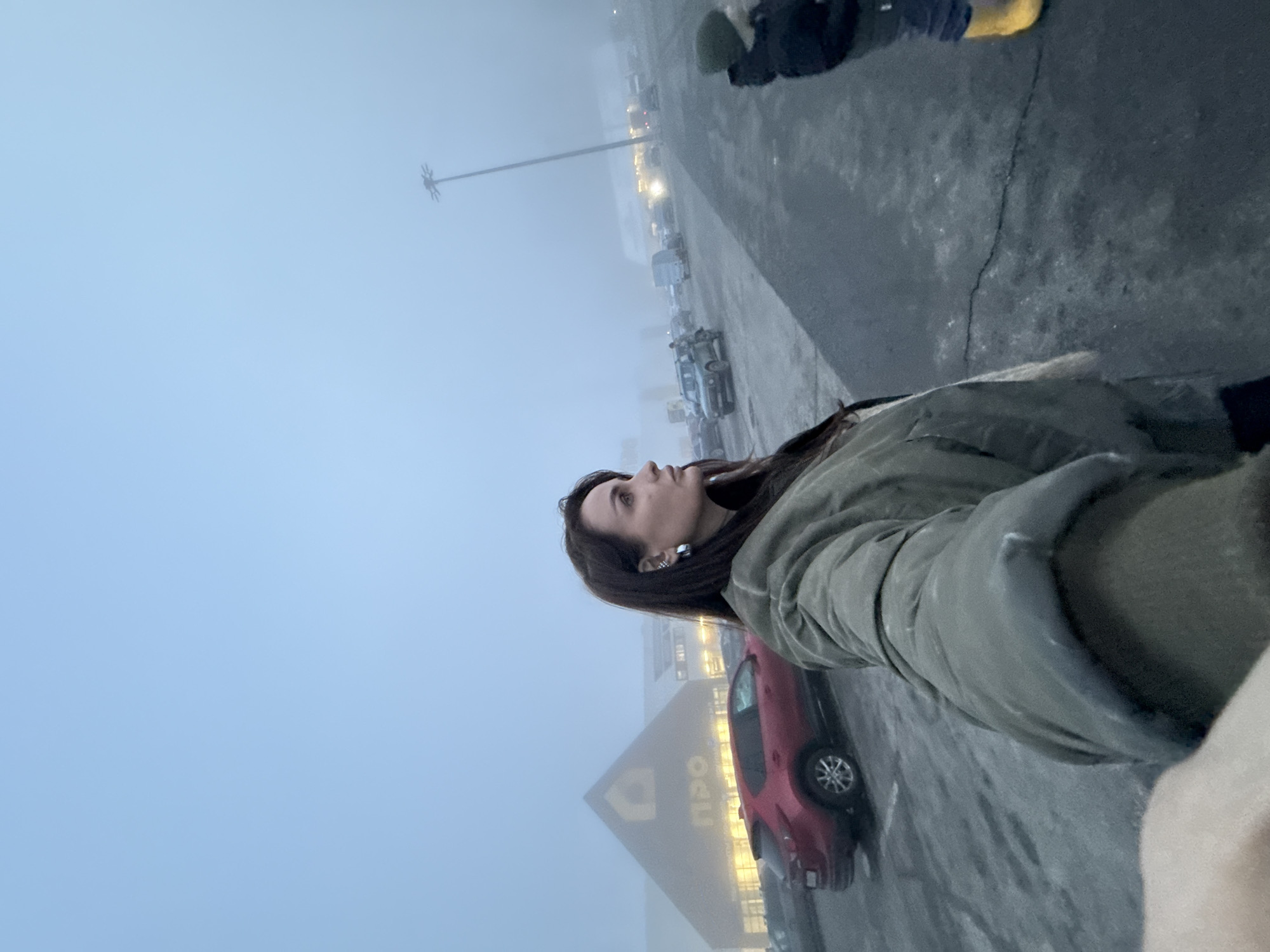 Woman stands in foggy parking lot outside Izhevsk store