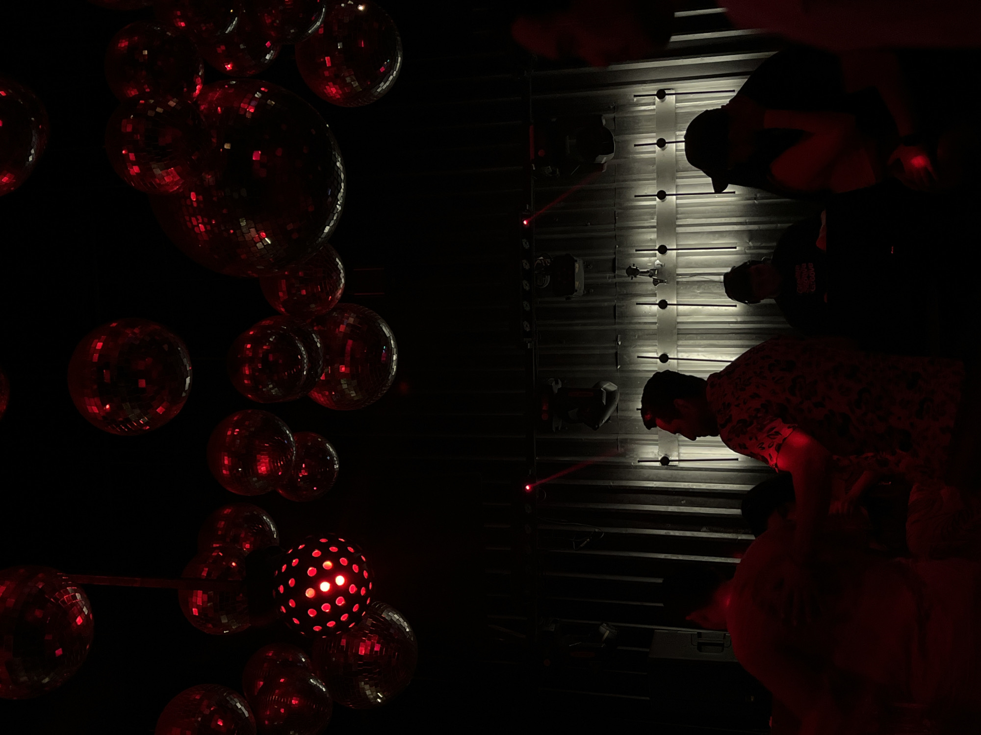Nightclub scene with red-lit disco balls observed in Coatzacoalcos