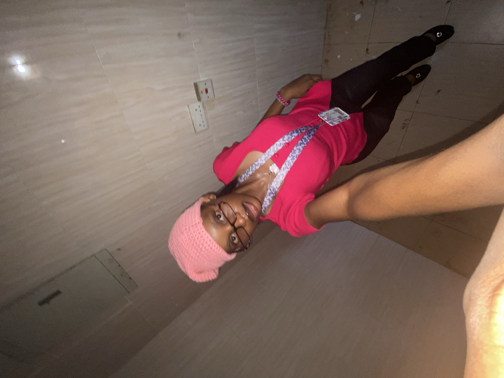 Person in pink beanie takes multiple selfies indoors