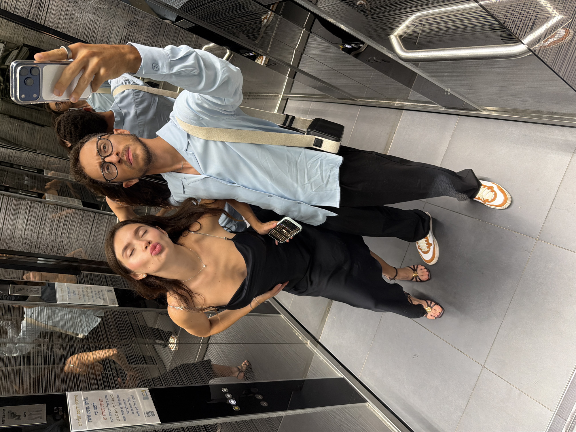 Elevator mirror selfie, black slip dress and strappy heels