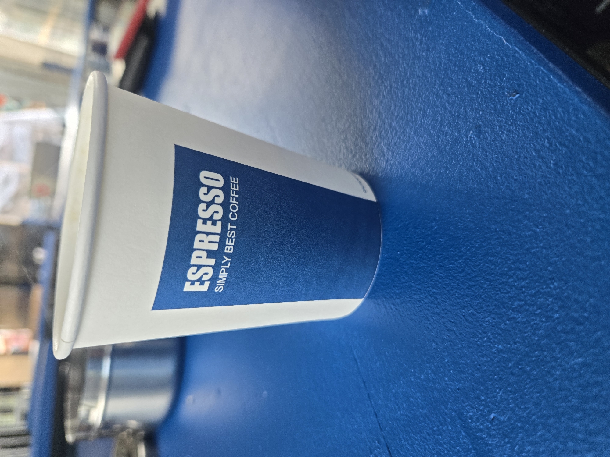 Coffee cup and lighter documented on blue surface
