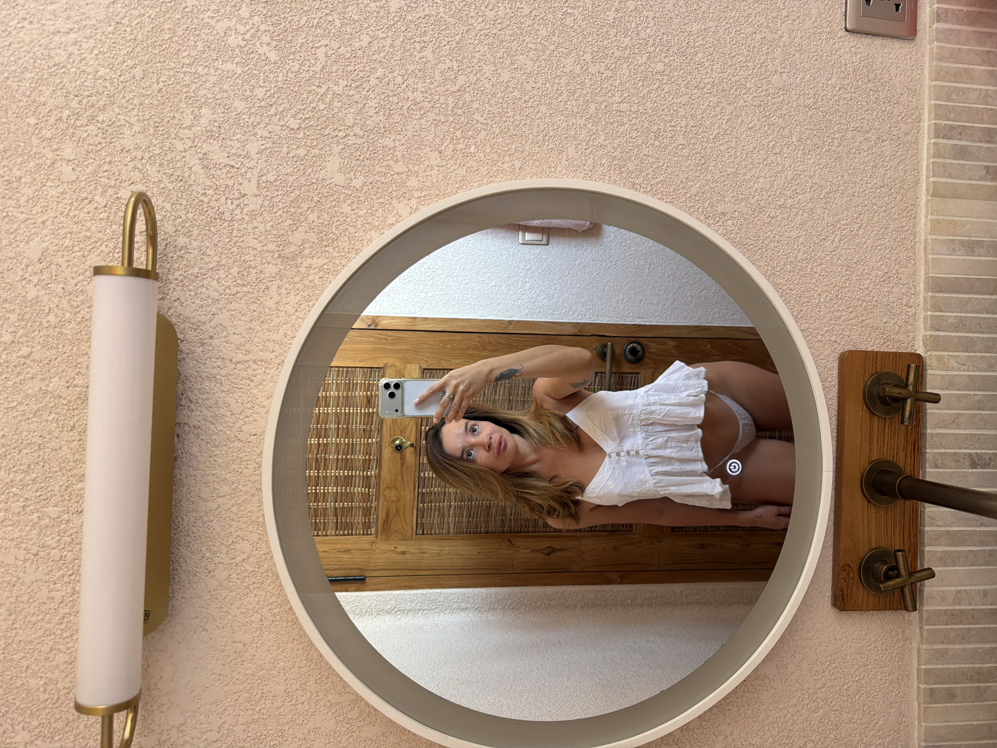 Woman takes mirror selfies in bathroom in Mengwi, Indonesia