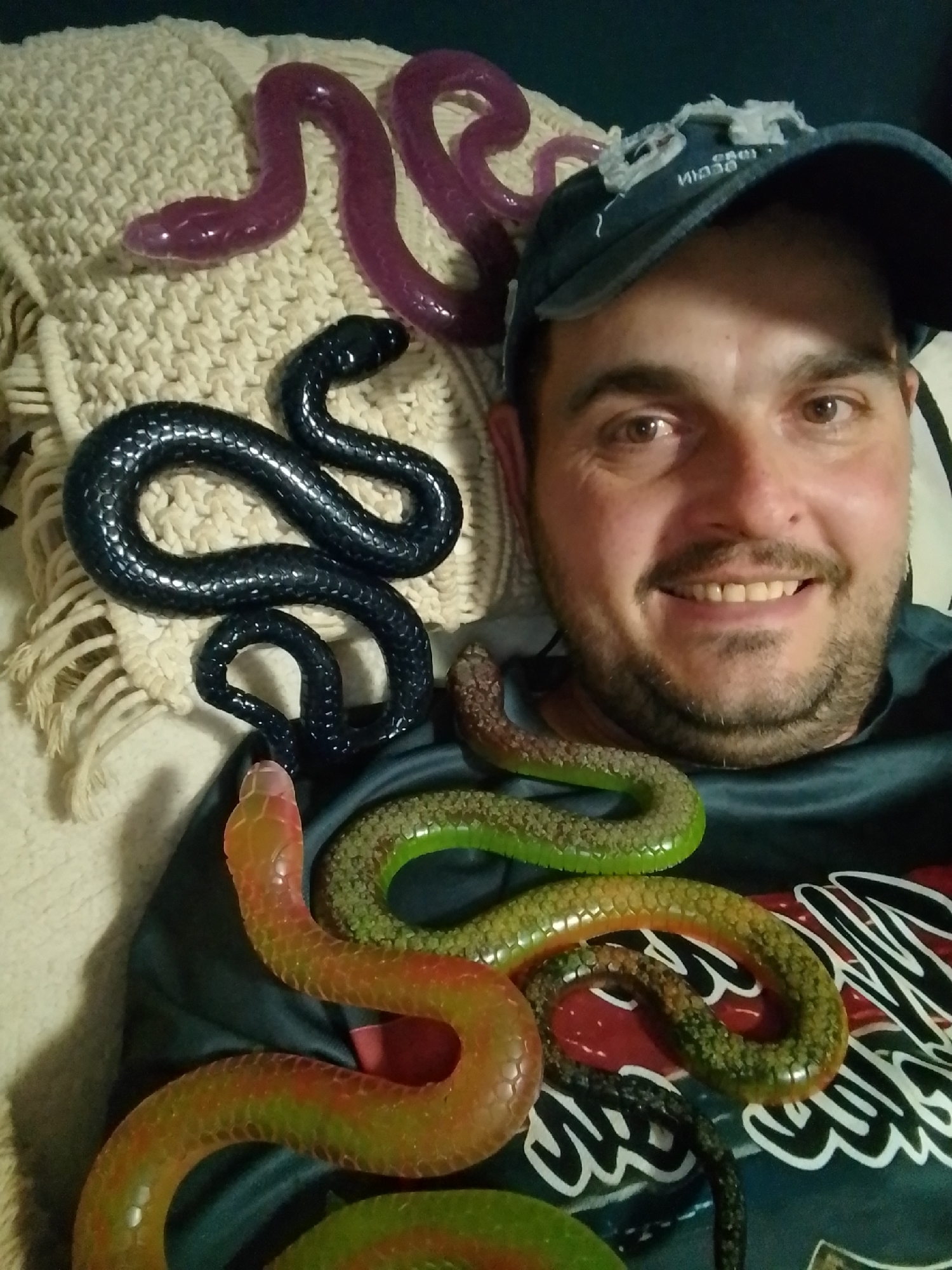 Toy snakes arranged on and around a person indoors in Wedel