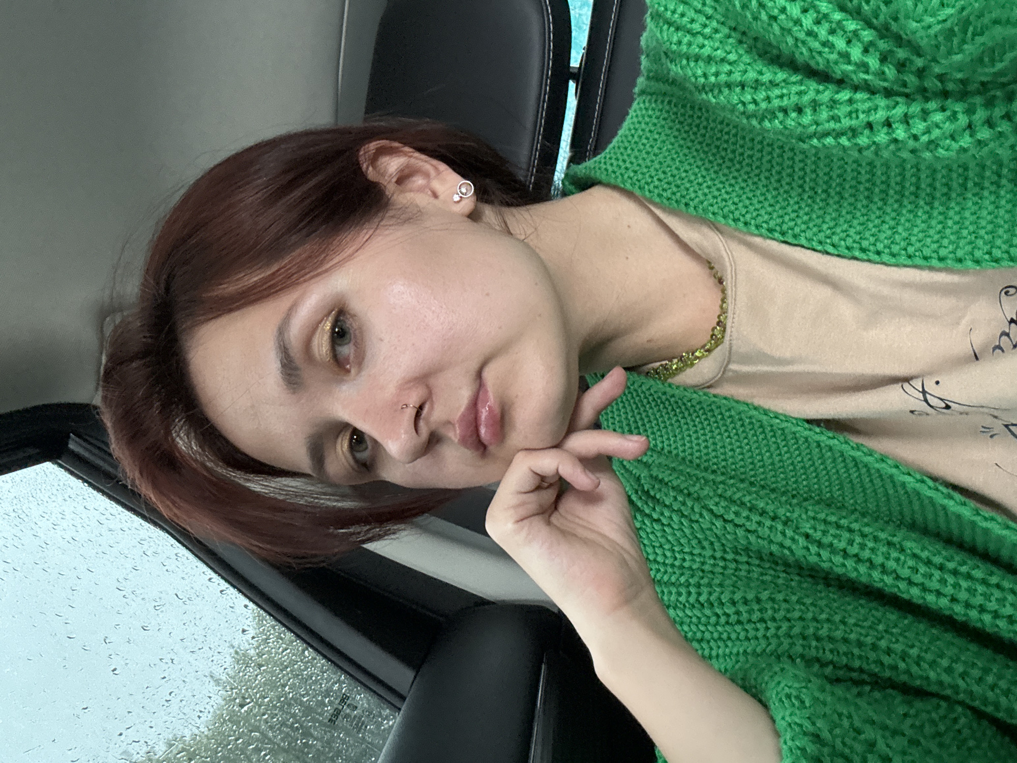 Inside a parked car in Naberezhnye Chelny, green cardigan and necklace