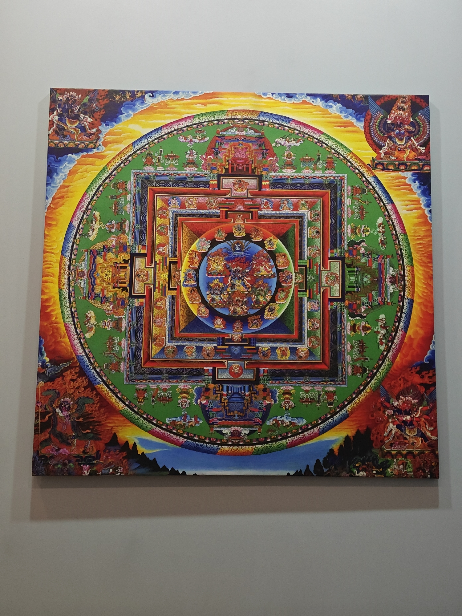 Tibetan mandala and female figurine observed in indoor setting