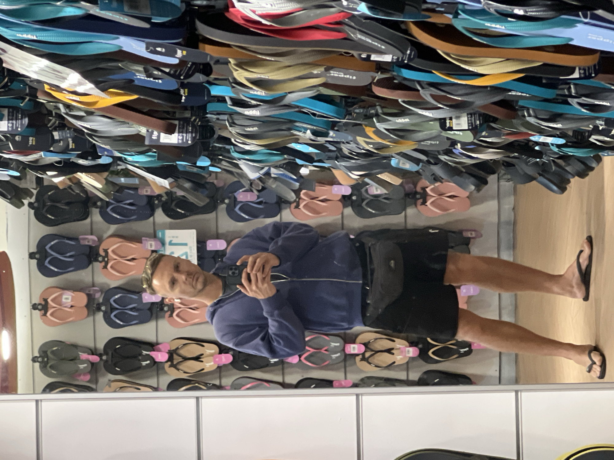Man browses flip-flop display at Denpasar store