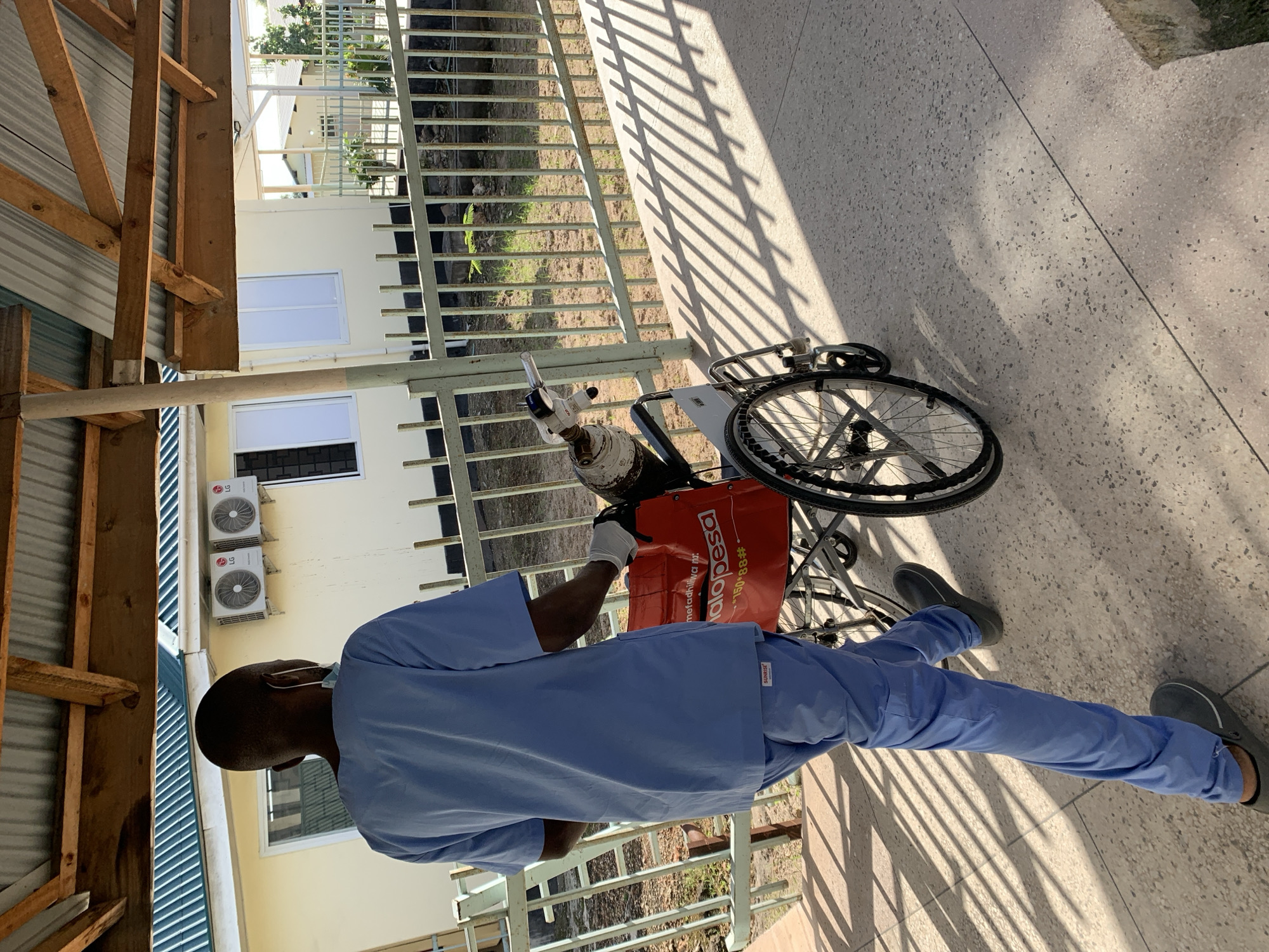 Medical worker transports patient with oxygen at Dar es Salaam facility