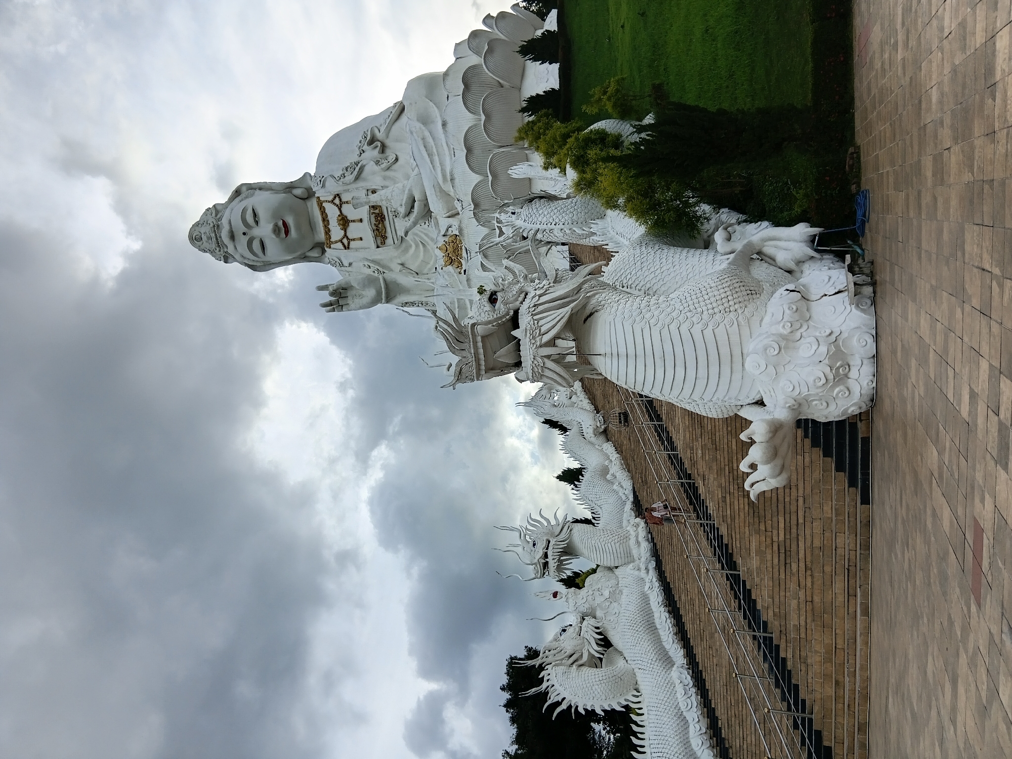 White deity and dragon statues at a hillside religious site in northern Thailand