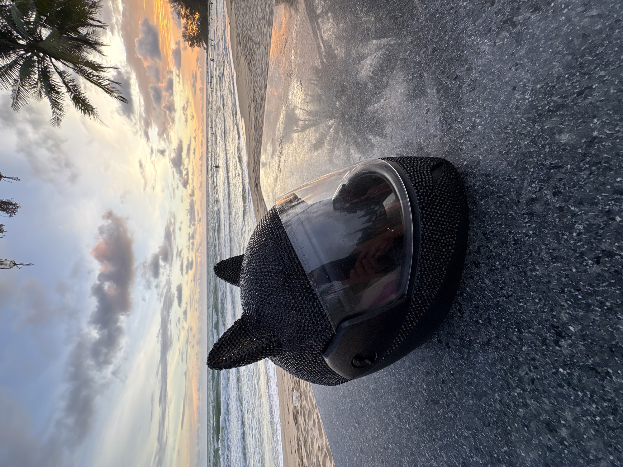 Cat-eared helmet and a palm-fringed sunset beach scene