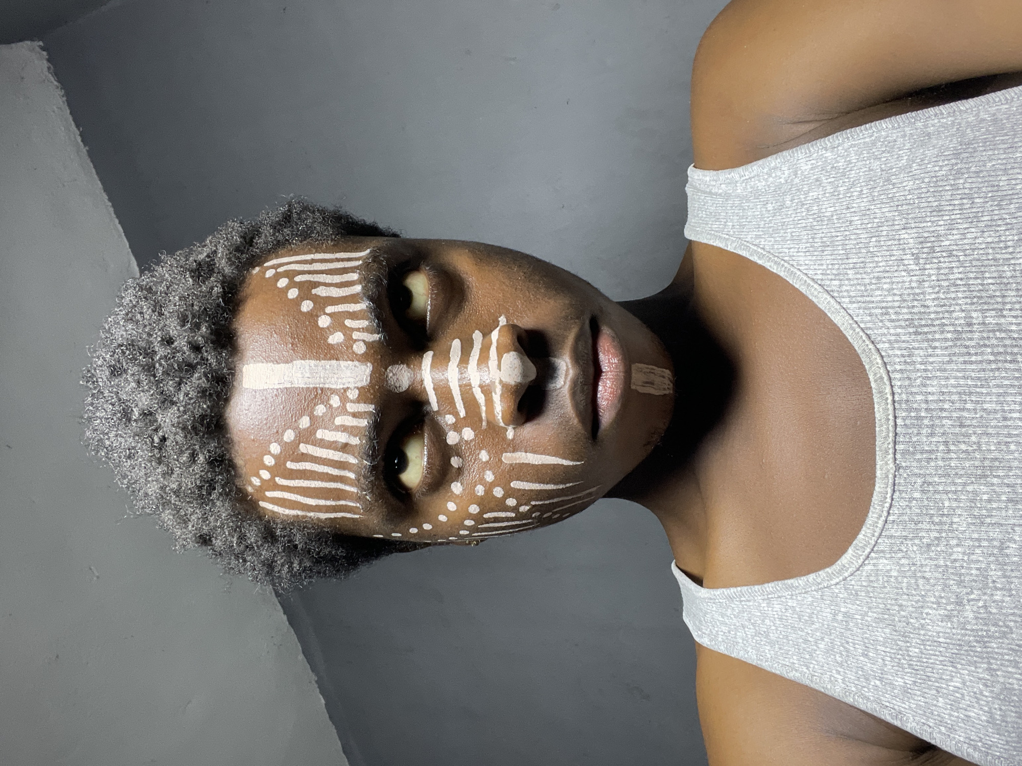 Person displays traditional white face paint in Nkpor, Nigeria