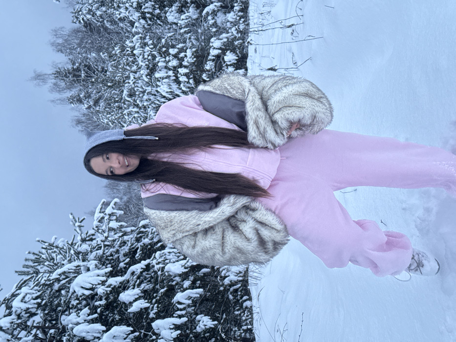 Woman in pink poses in snowy Russian forest