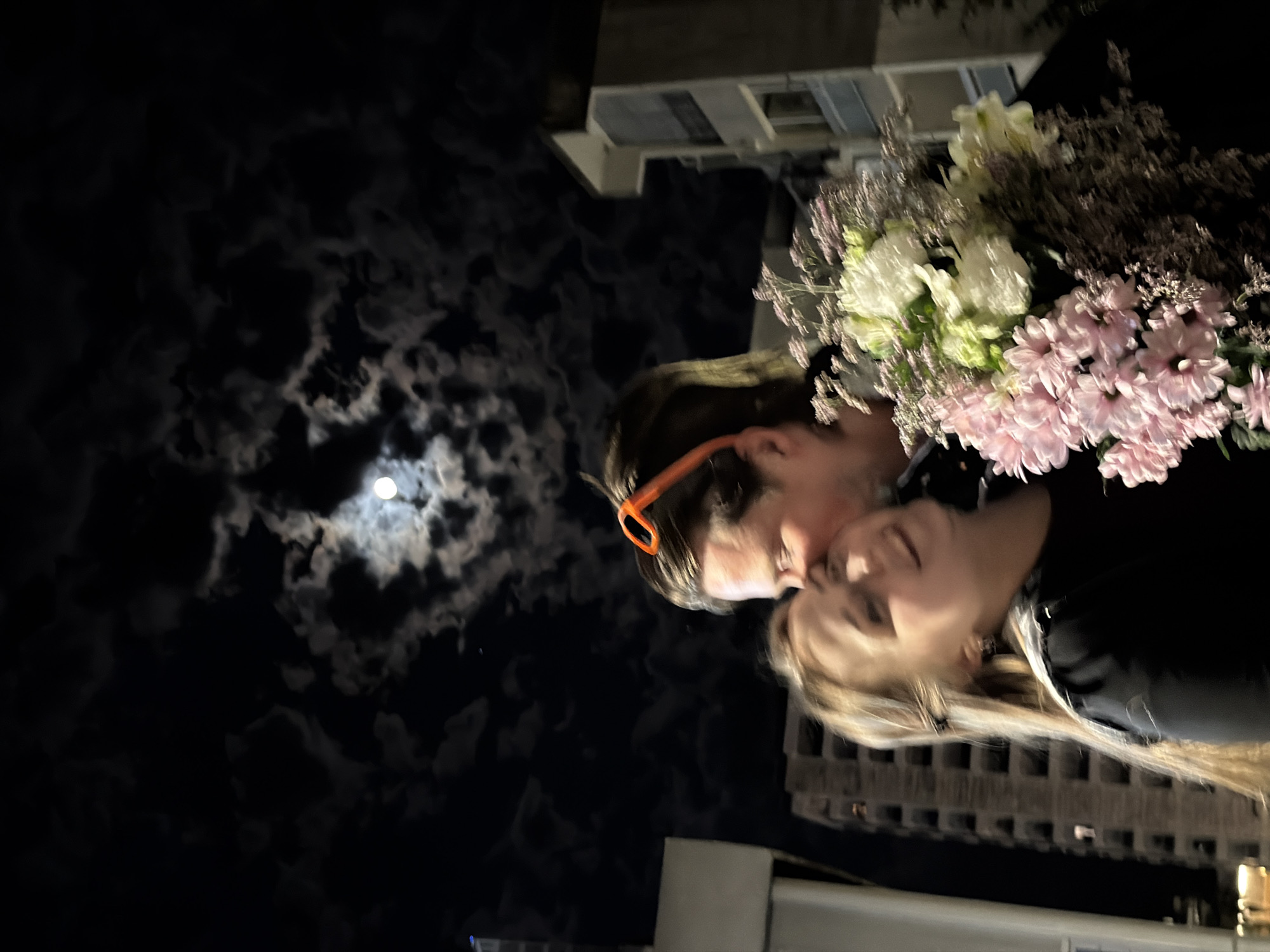 Evening social gatherings captured under prominent moonlight in urban setting