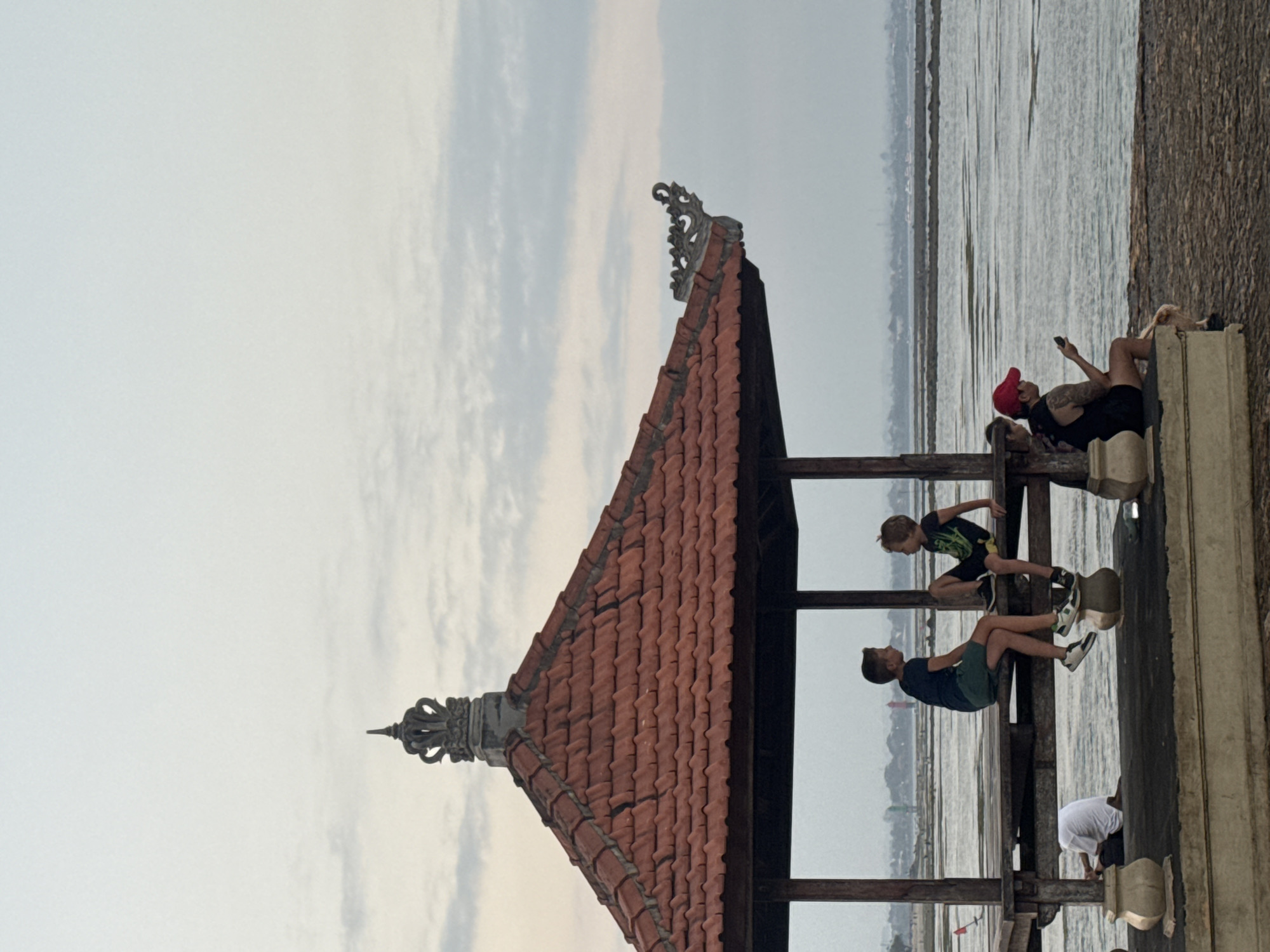 Conversation inside a carved Balinese pavilion in Denpasar