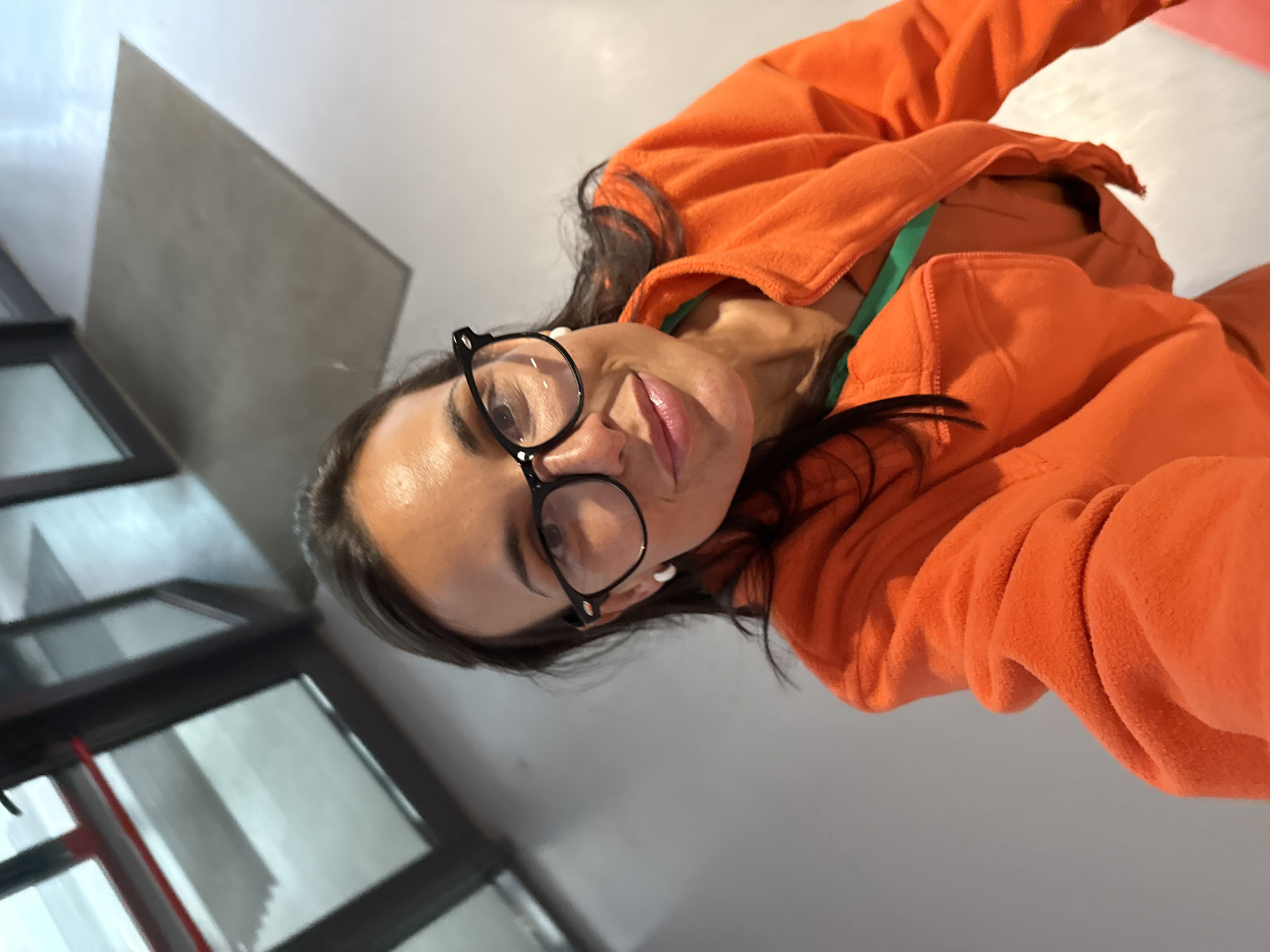 Quick selfie inside a Pleven building, orange jacket and green lanyard