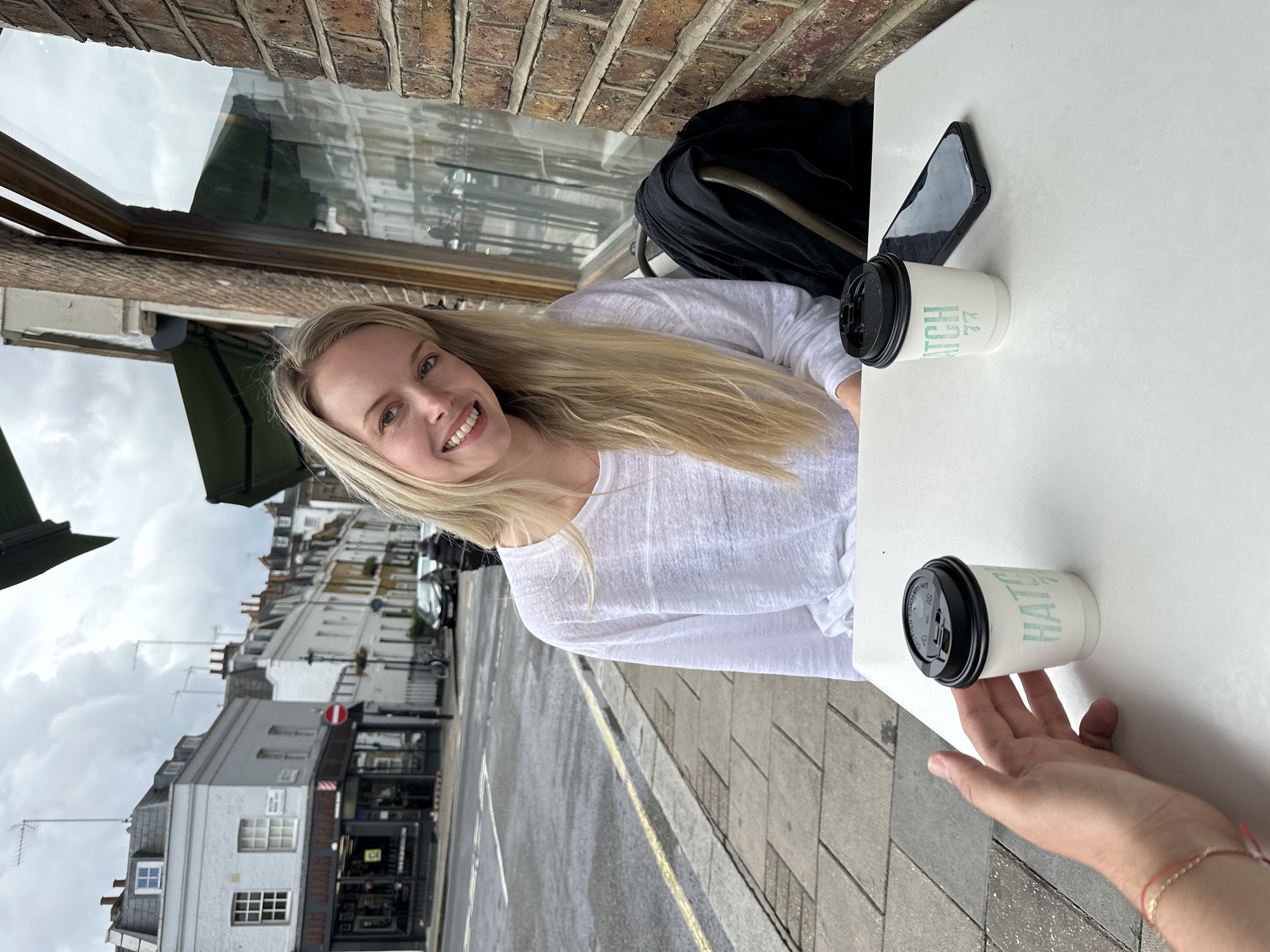 Woman enjoys coffee at London outdoor cafe