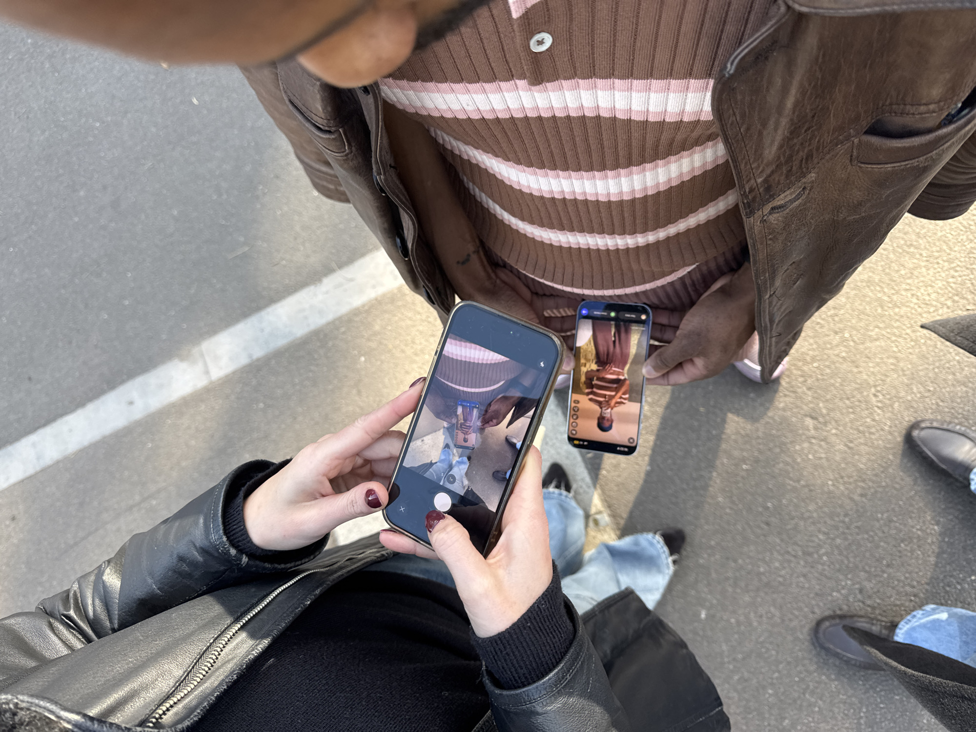 Couple photographing with smartphones captured in Folkestone street scene