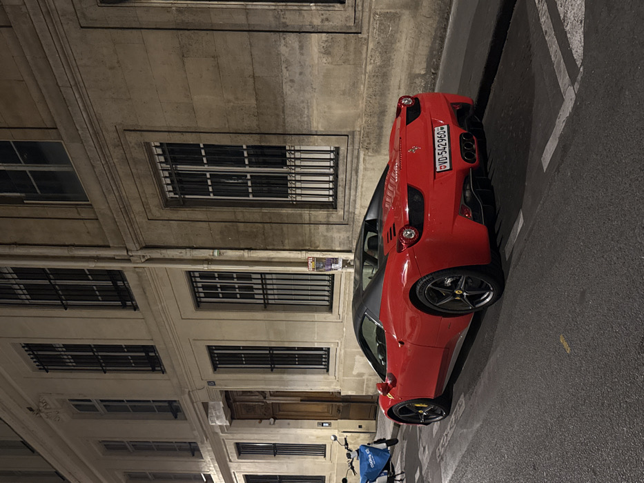 Red Ferrari spotted parked on Paris street at night