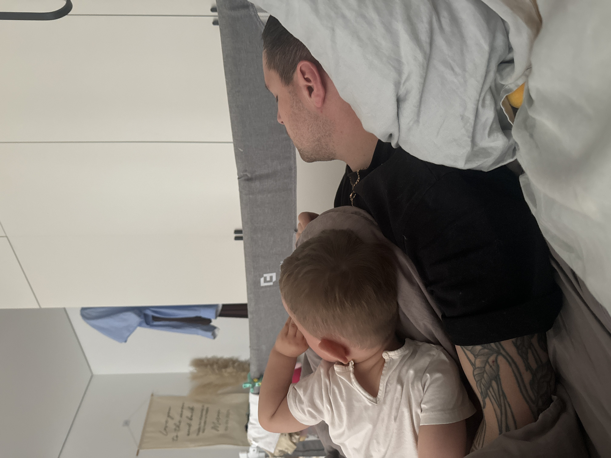 Father and child share quiet bedroom moment