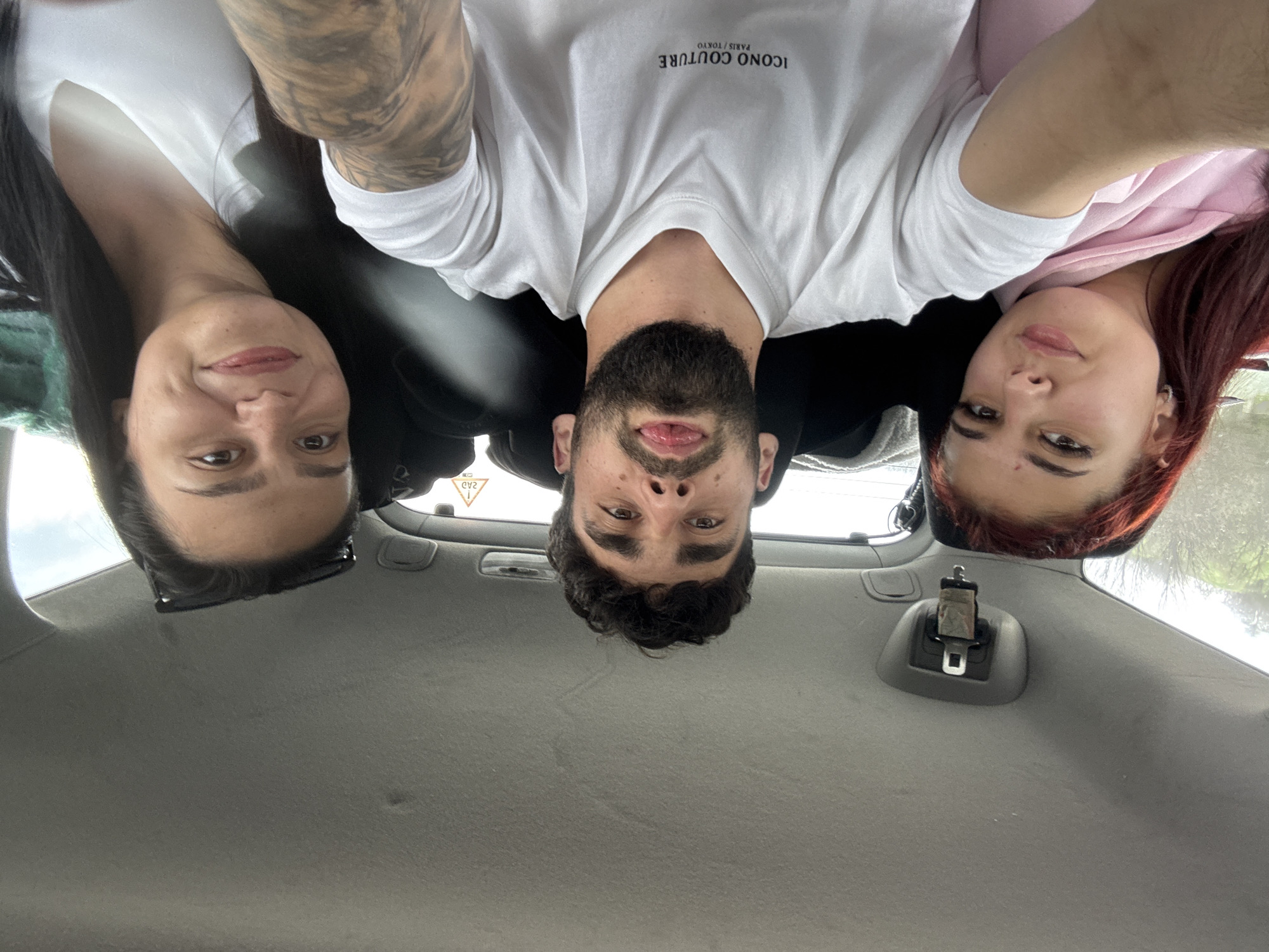 Three people photographed from vehicle, bearded man in designer shirt