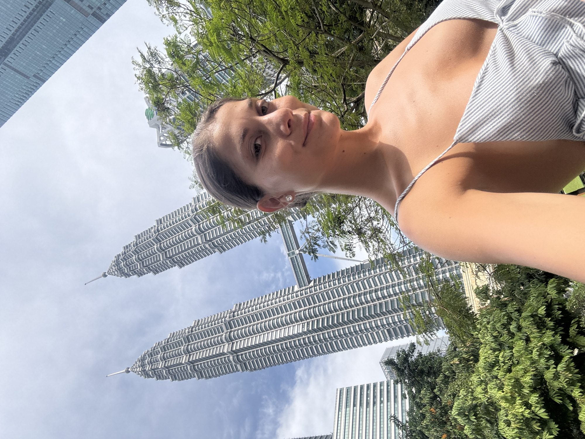 Woman takes selfies at KLCC Park near Petronas Towers