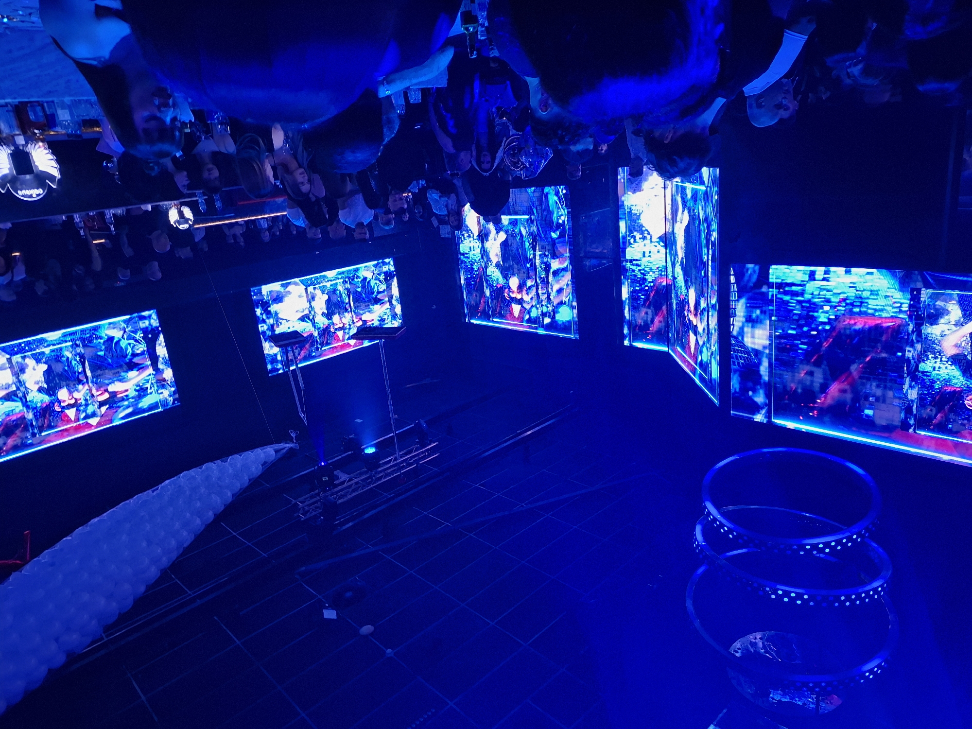 Blue-lit venue with hanging screens captured in Plovdiv