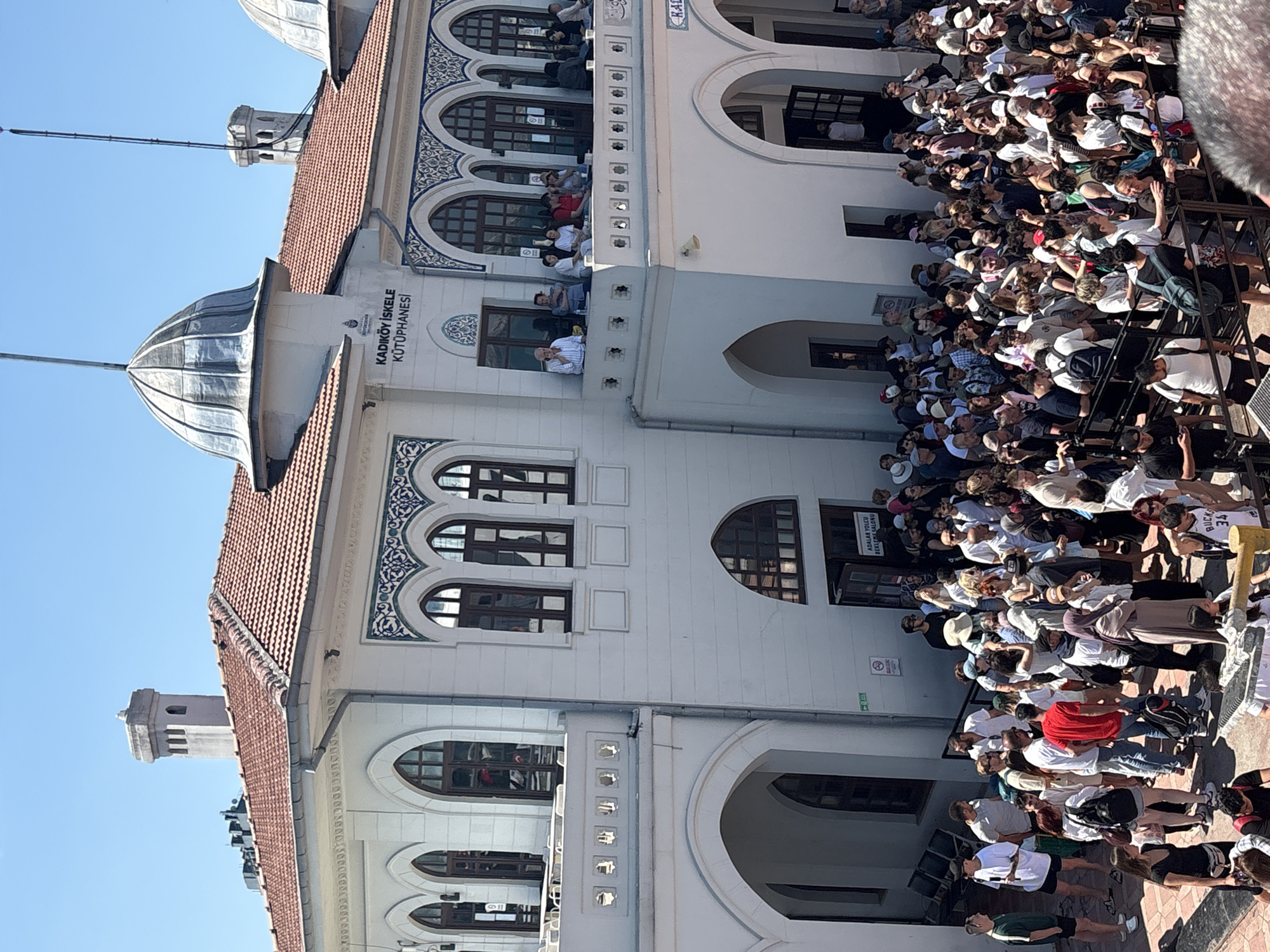 Morning crowd gathers at Kadıköy ferry station on sunny day