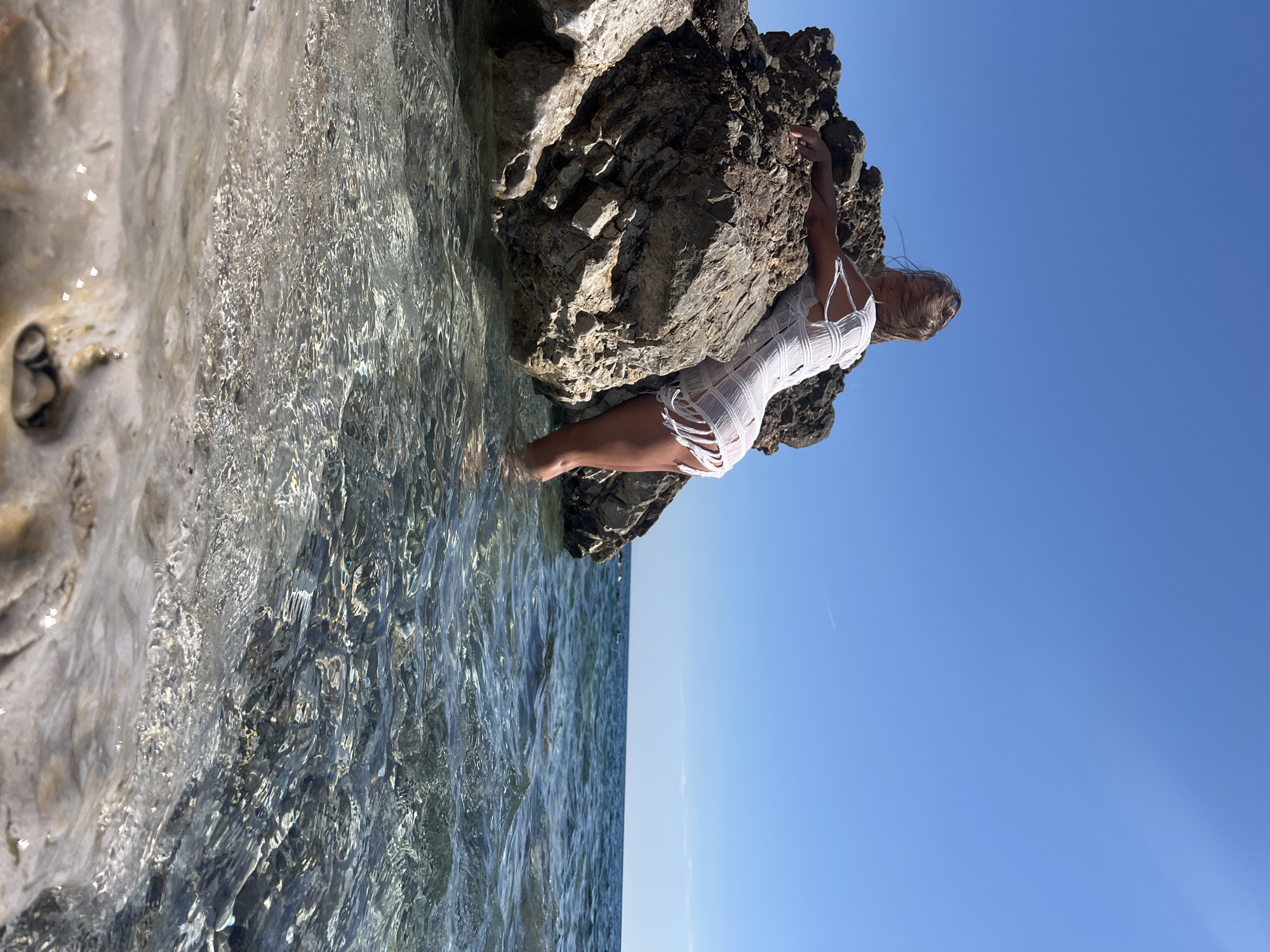Woman sunbathes on rocky beach in Prijevor, Montenegro