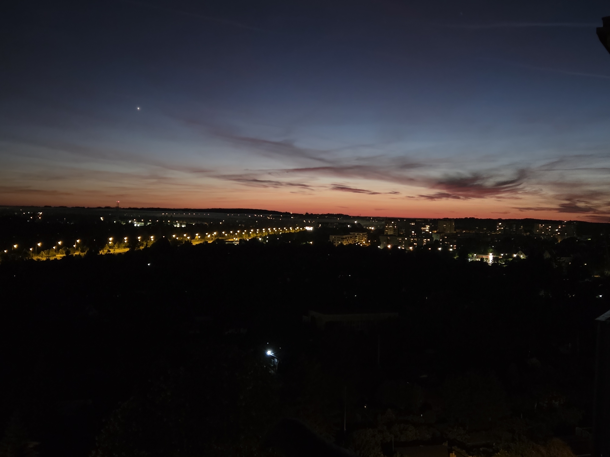 Nighttime cityscape captured in Szczecin with celestial object visible