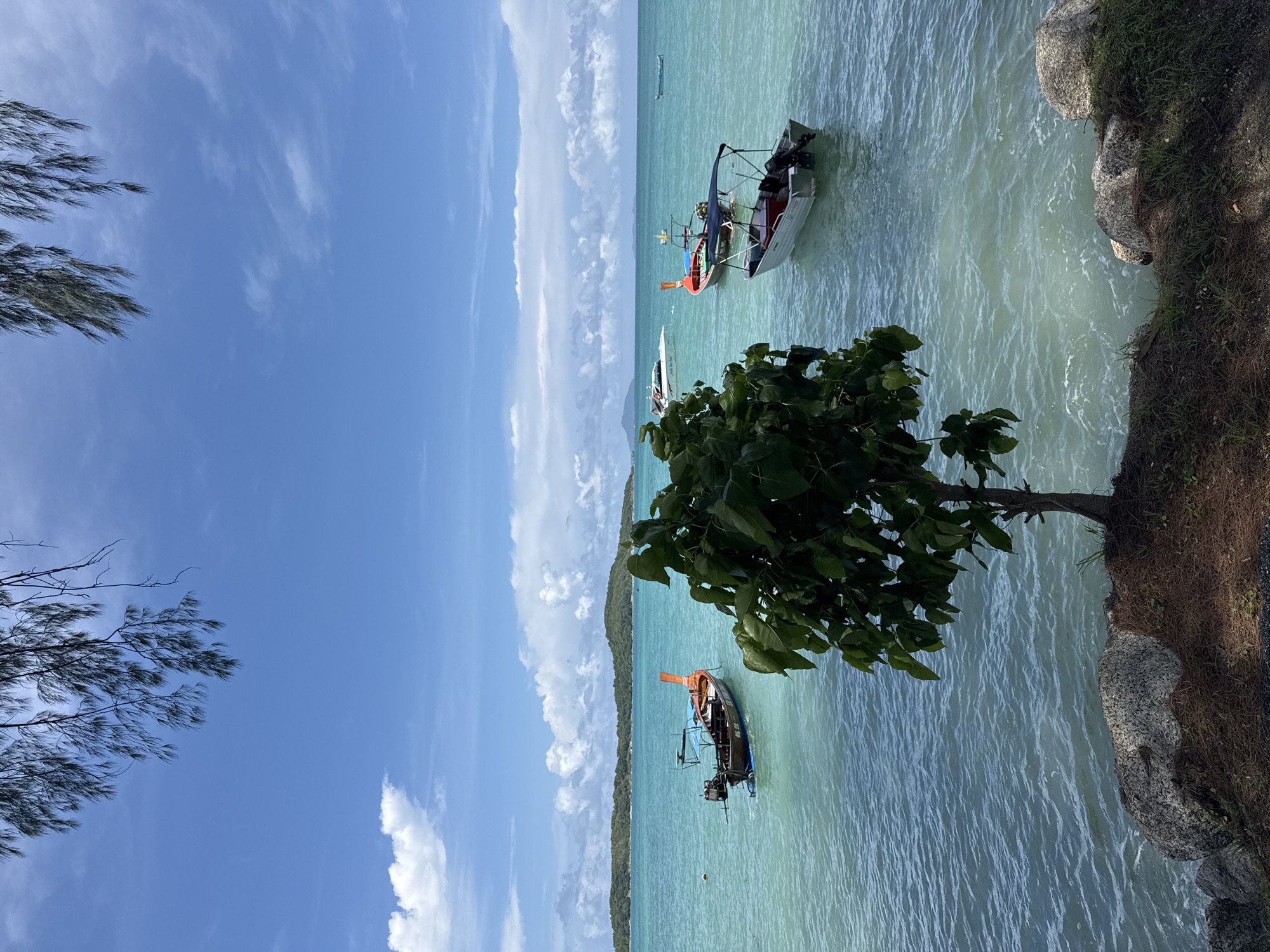 Calm morning at Rawai Bay, long-tail boats on turquoise water