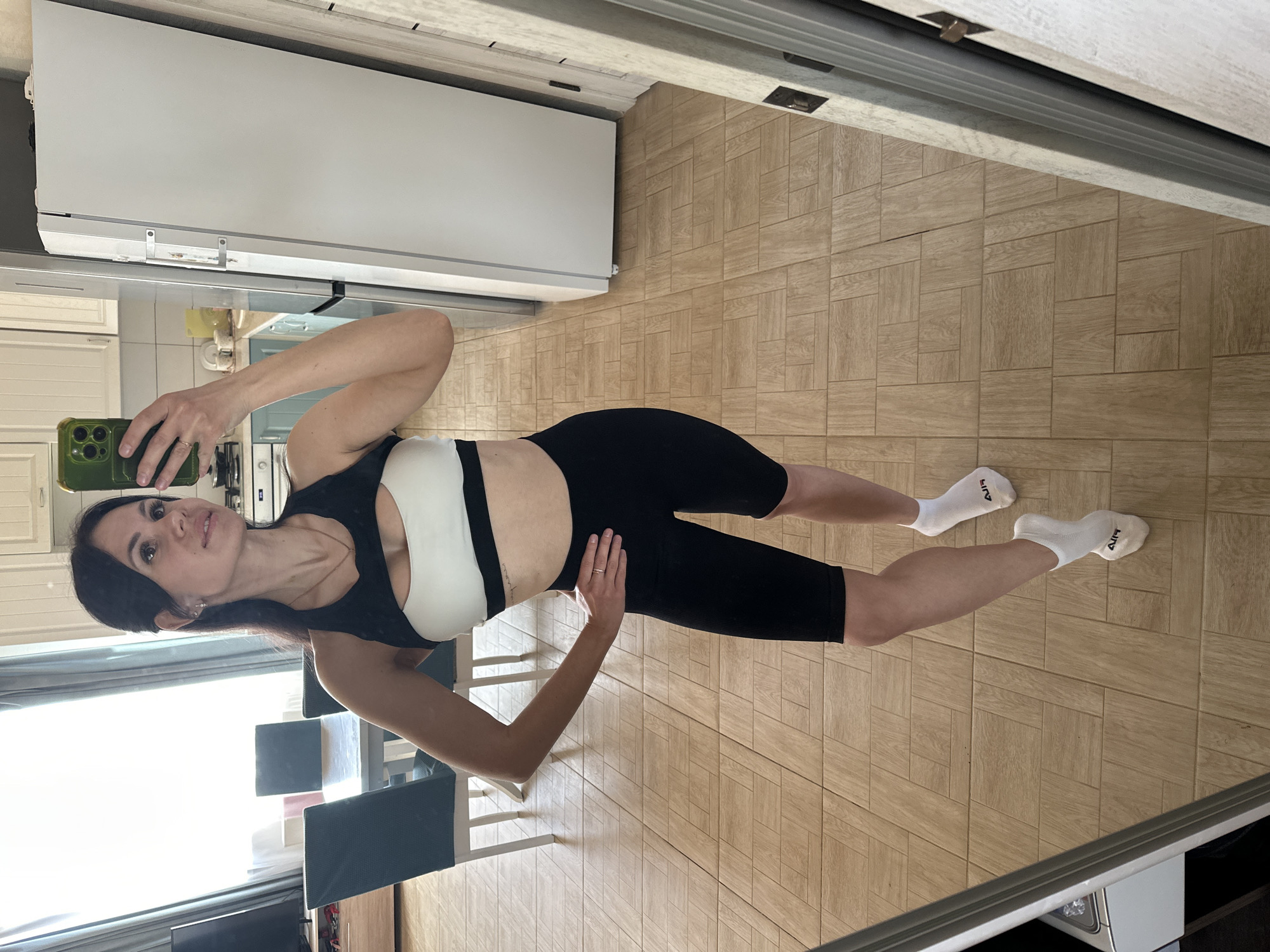 Woman takes kitchen selfie in athletic wear