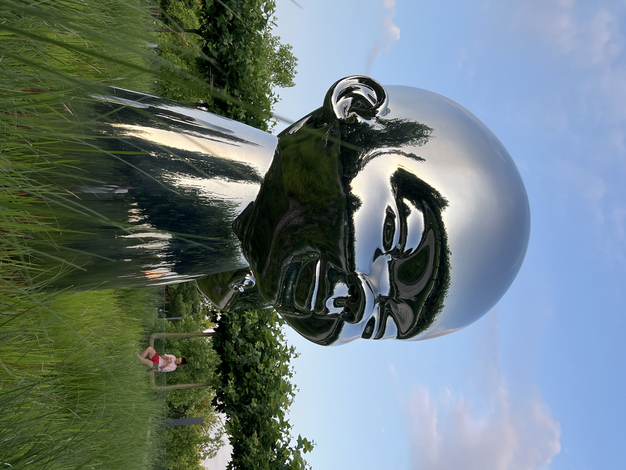 Afternoon in a Krasnodar park with sculptures, fountains, and locals.