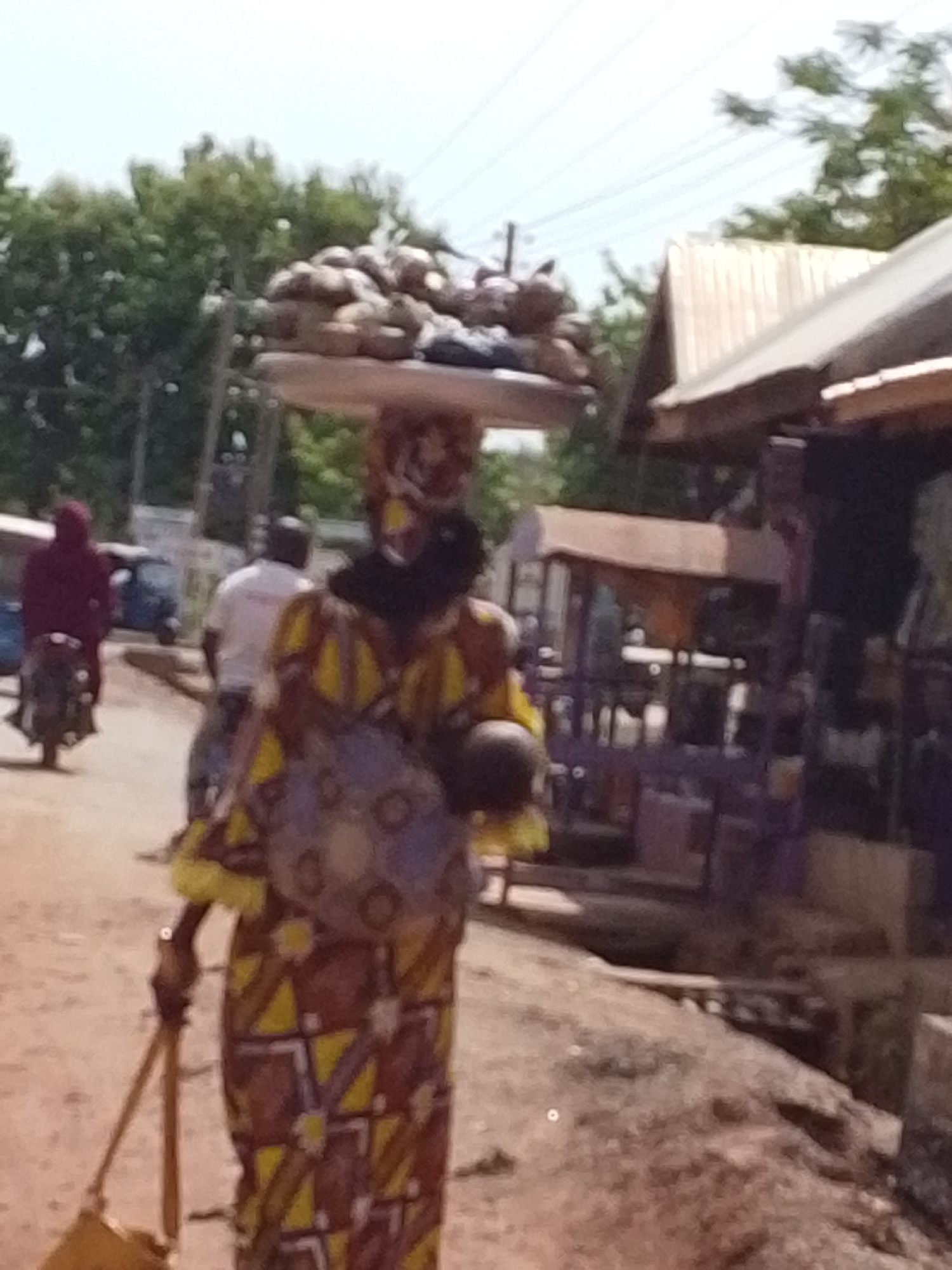 Woman walks dusty street in Tamale, Ghana