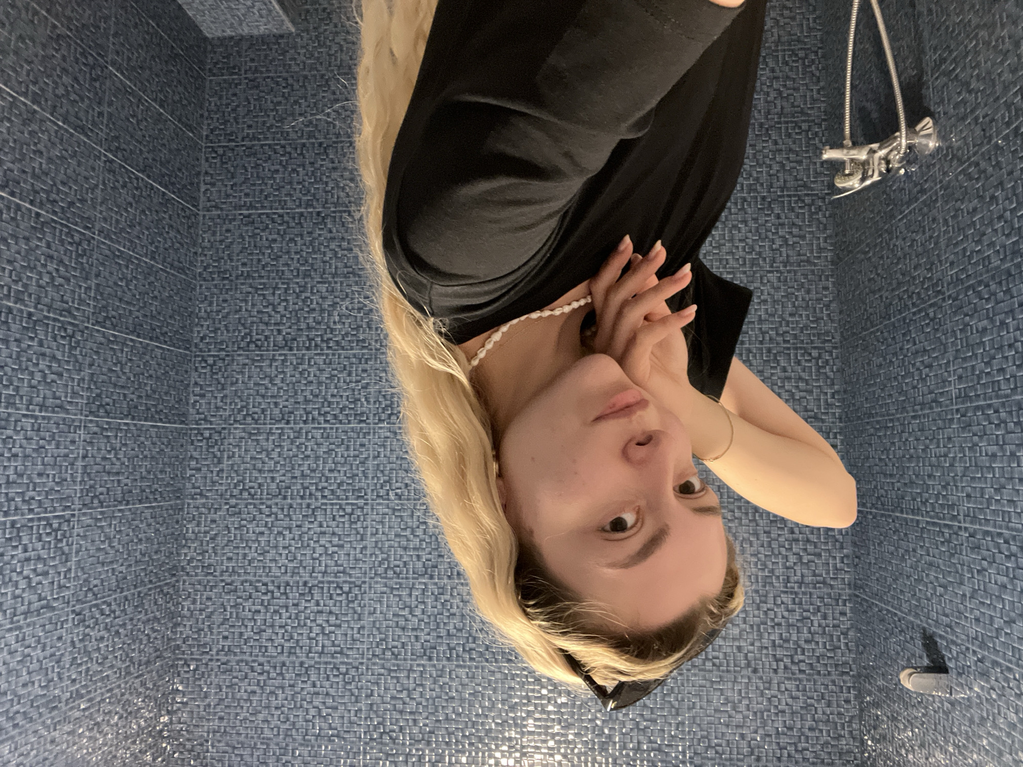 Young woman takes bathroom mirror selfies in morning session