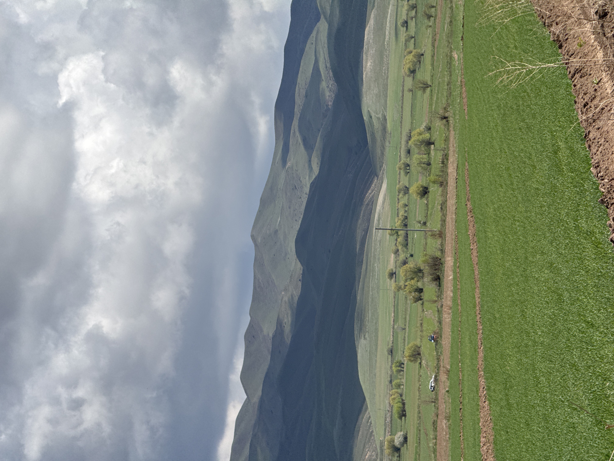 Overcast morning captured over green mountains in Tilekmat, Kyrgyzstan