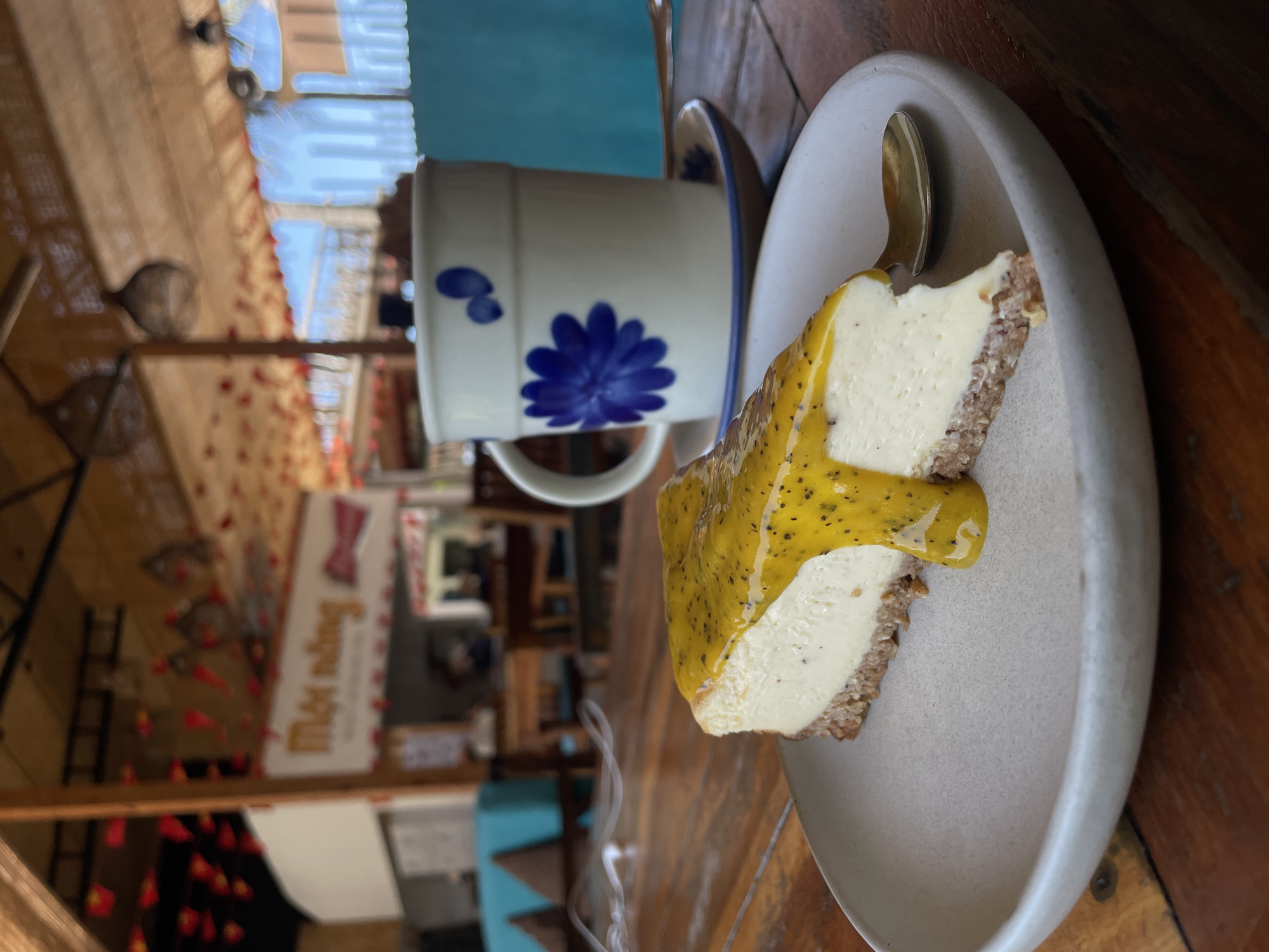 Passionfruit cheesecake at a café with a mural backdrop